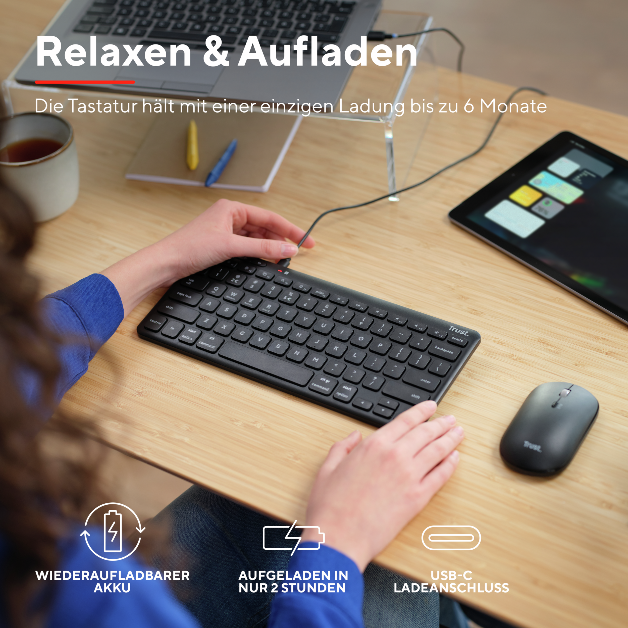 Kobieta używająca czarnej klawiatury i myszy bezprzewodowej na biurku z laptopem.