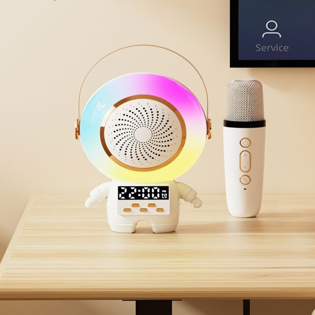 Un altavoz con forma de astronauta con luces, un micrófono y una mesa. Una pantalla en el fondo.