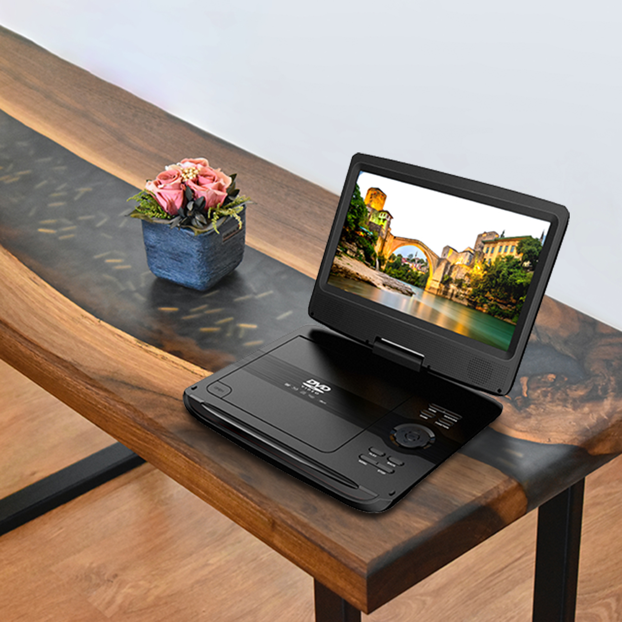 Odtwarzacz DVD wyświetlający scenę z mostem na drewnianym stole.