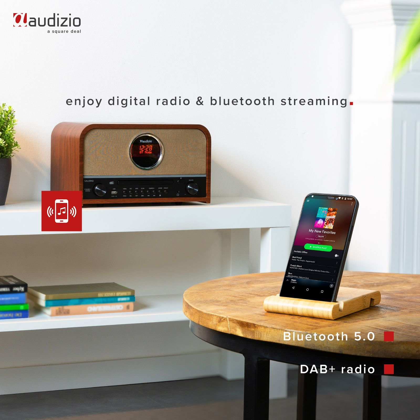 Ein Holzradio und ein Telefon auf einem Ständer. Das Telefon zeigt eine Musik-App. Text: digital Radio.