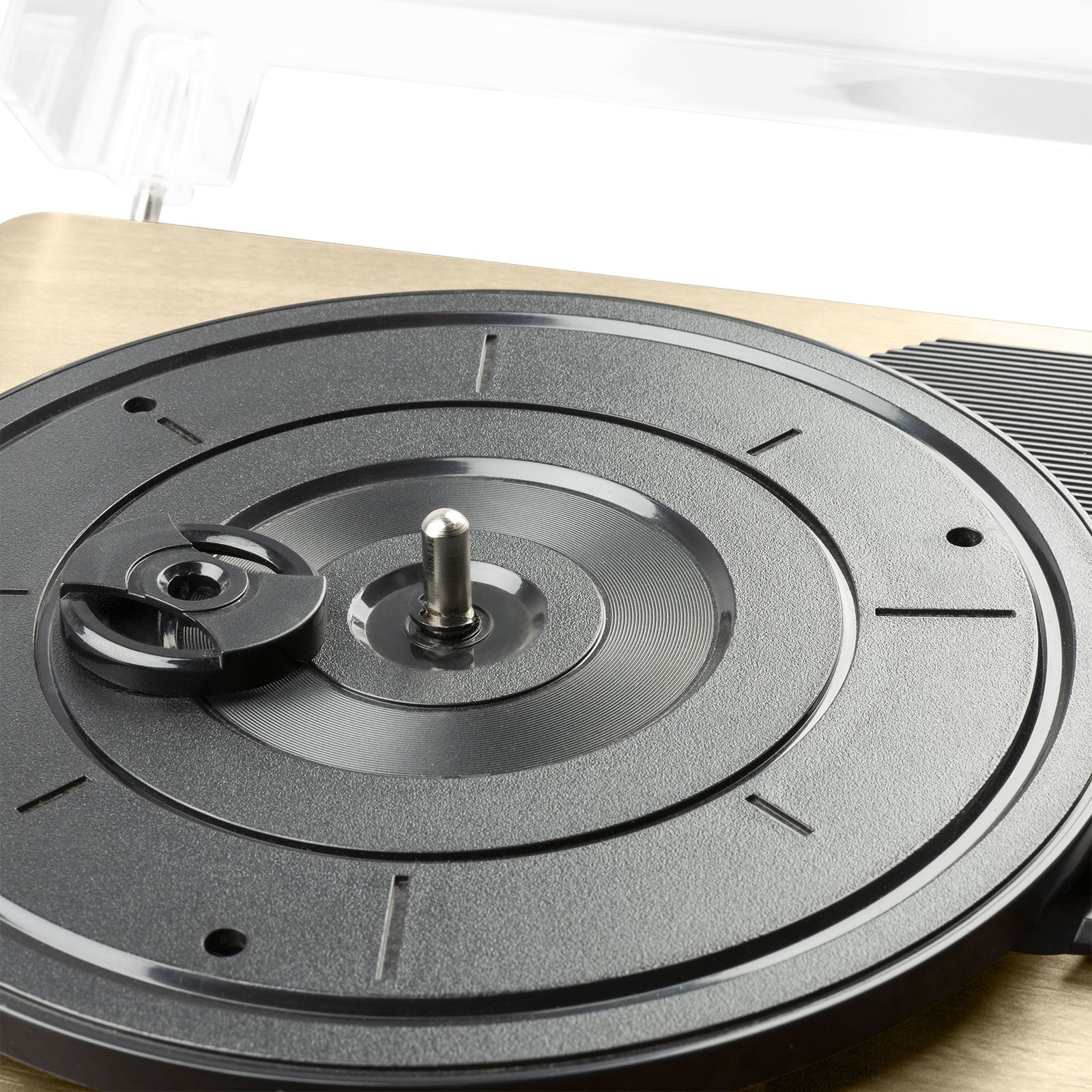 Nahaufnahme des Plattentellers eines Plattenspielers. Schwarze Farbe, mit Rillen und einer Mittelspindel.