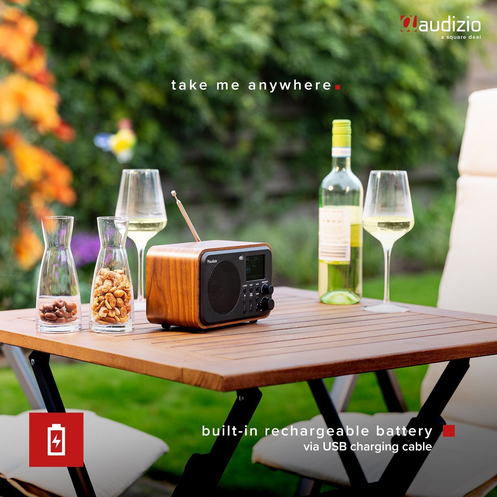 Holzradio auf dem Tisch. Weingläser, Weinflaschen, Snacks. Umgebung im Freien.