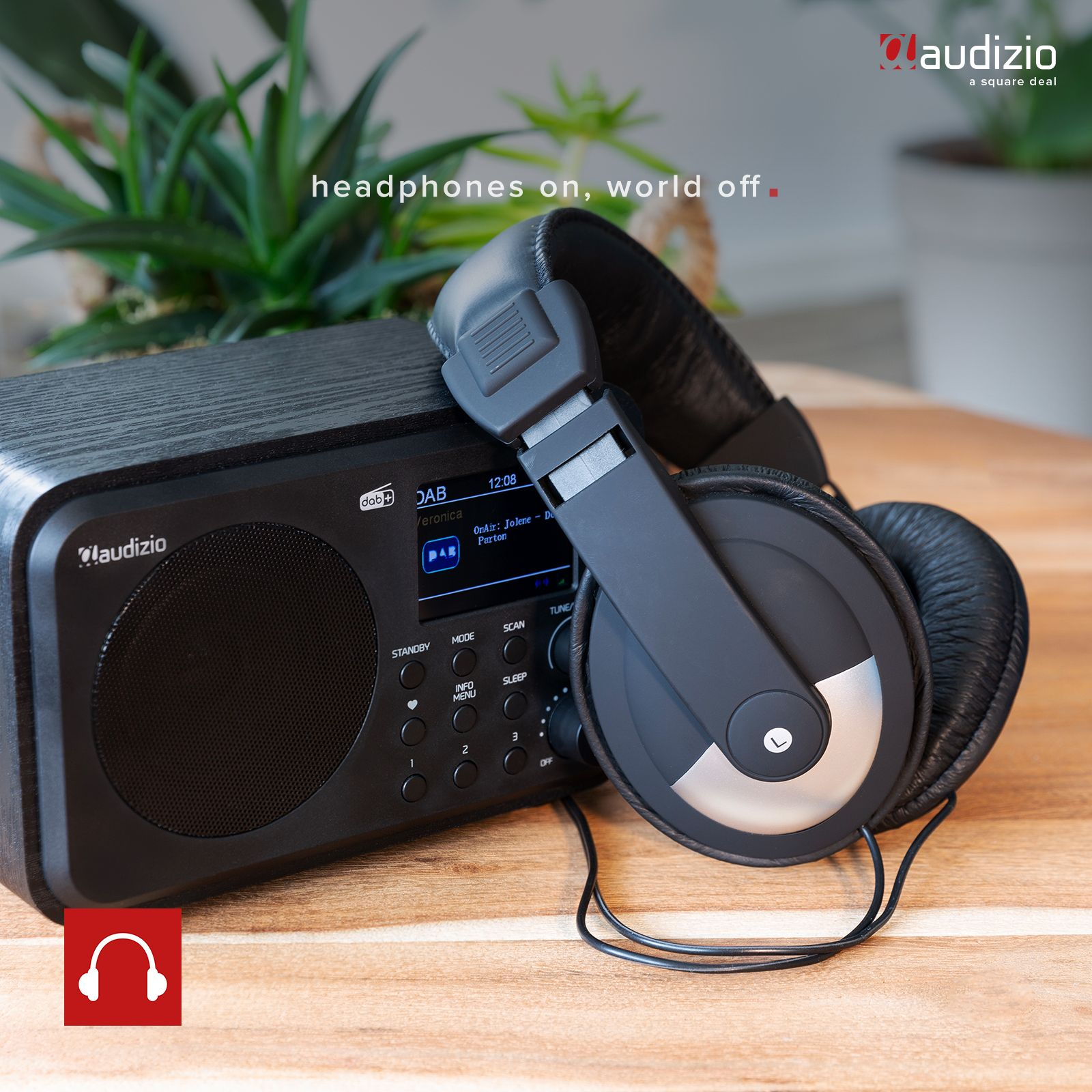 Una radio negra con auriculares. La radio tiene una pantalla y botones. Los auriculares son negros.