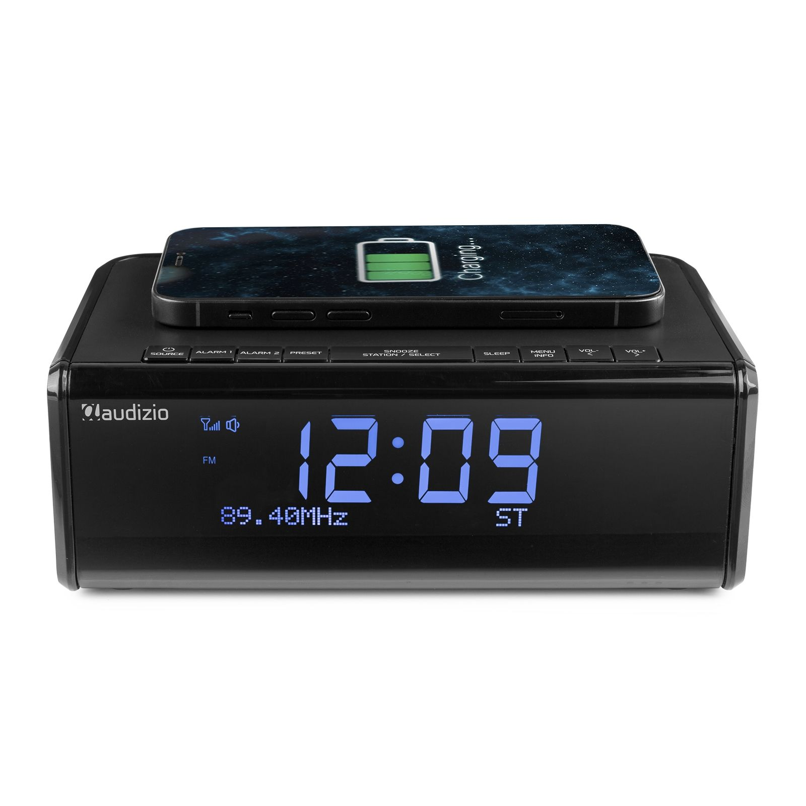 Schwarzer Wecker mit Smartphone oben drauf. Die Uhr zeigt Zeit und Ladestatus.