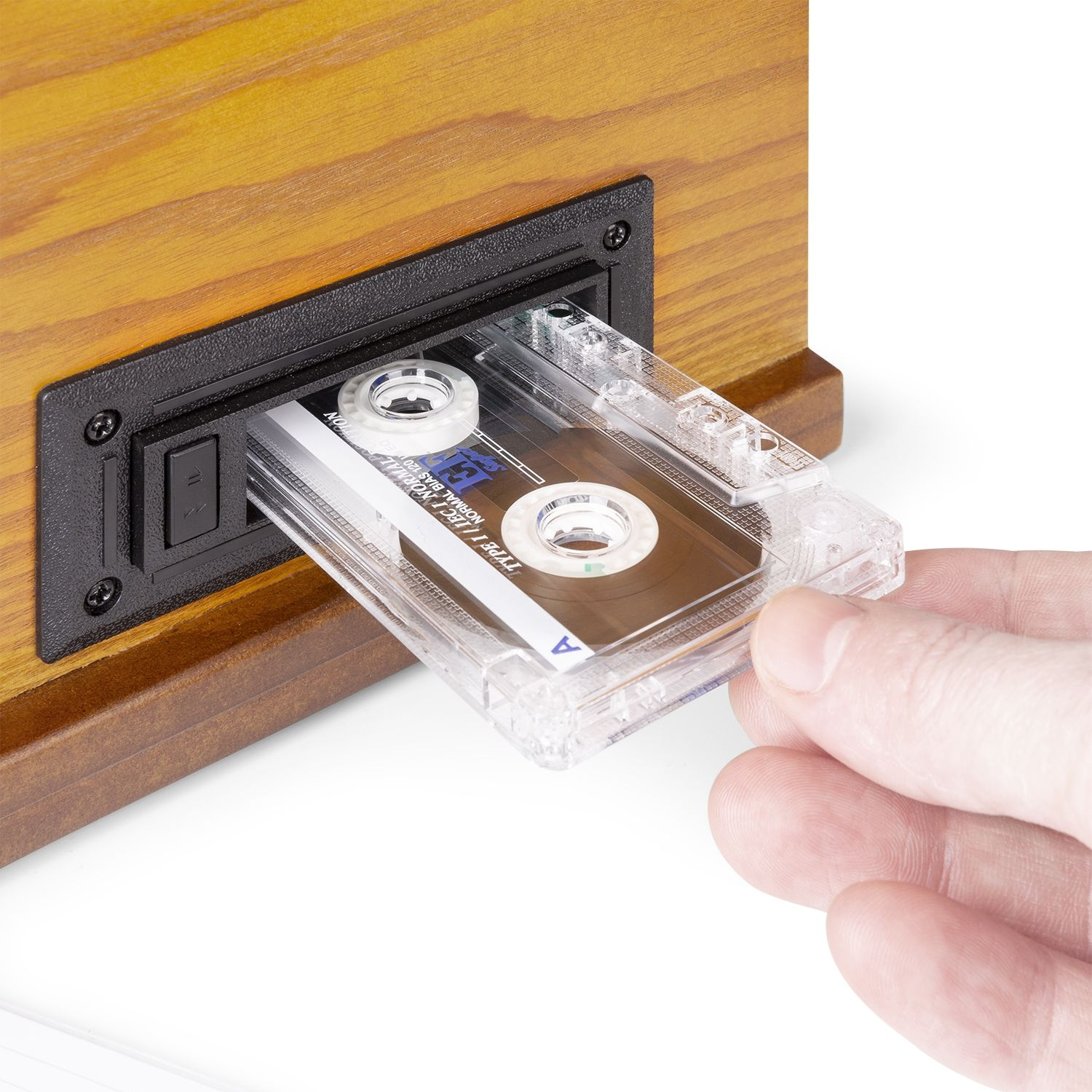 Una mano insertando una cinta de cassette en un estéreo de madera. La cinta es transparente.