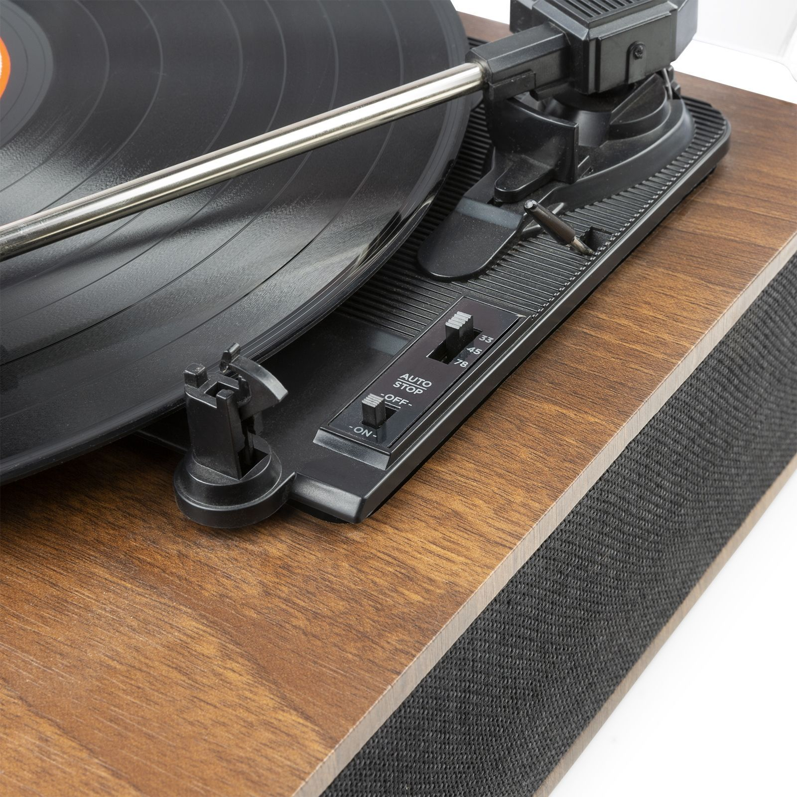 Primer plano de un tocadiscos con un disco negro sobre una superficie de madera.