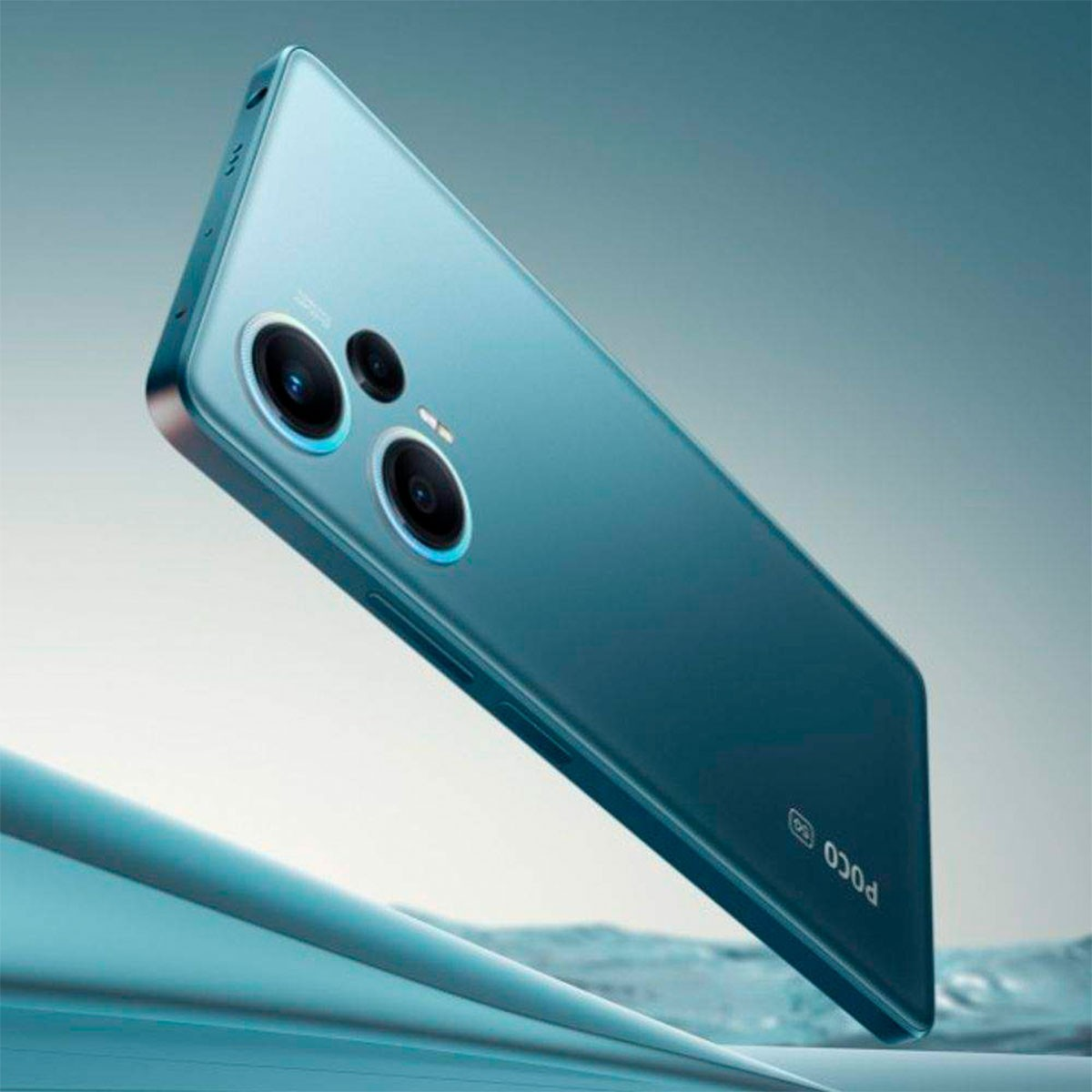 Niebieskozielony smartfon pod kątem. Posiada podwójne aparaty i logo Poco.