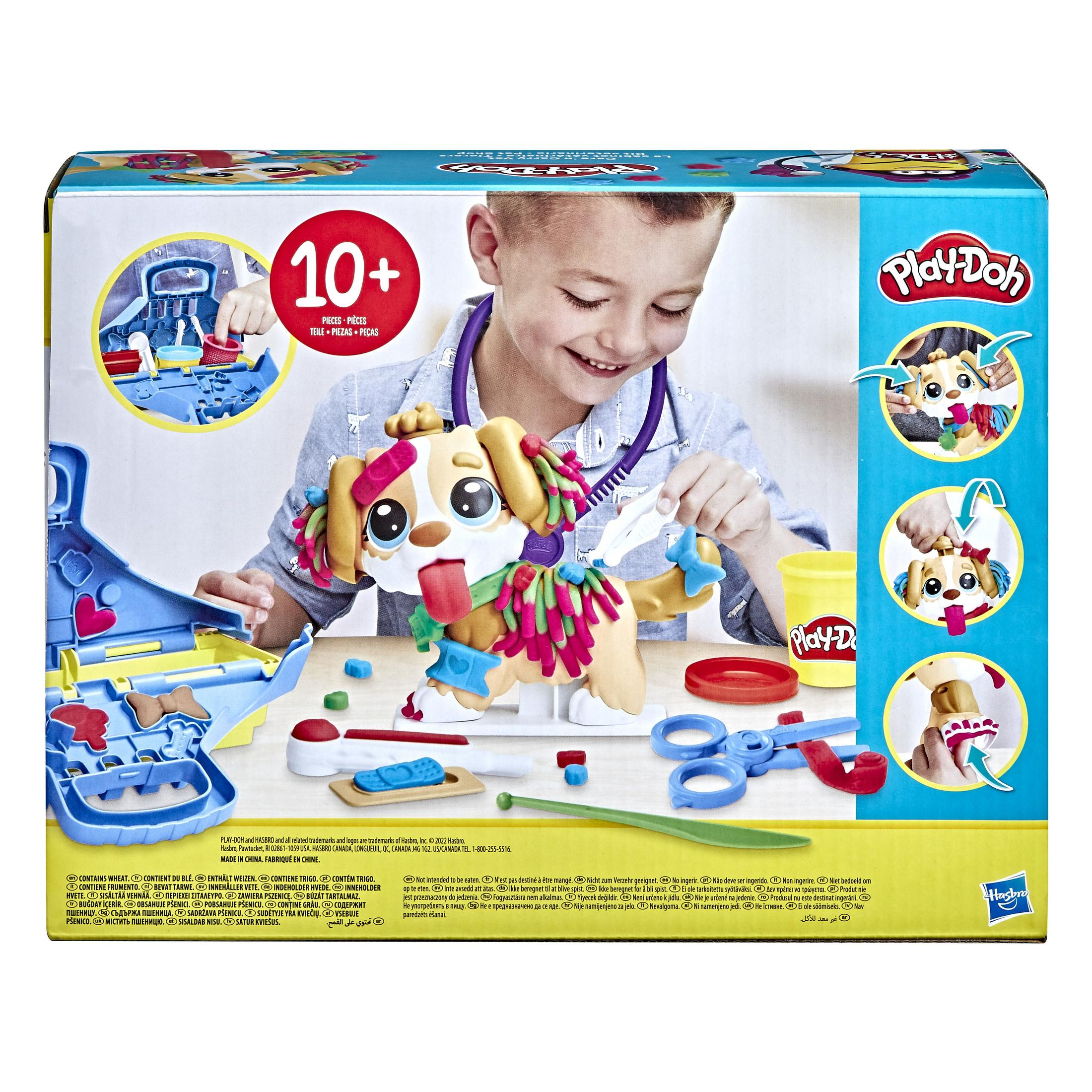 Un niño juega con un juguete de perro Play-Doh en una caja. El juguete tiene accesorios y Play-Doh.