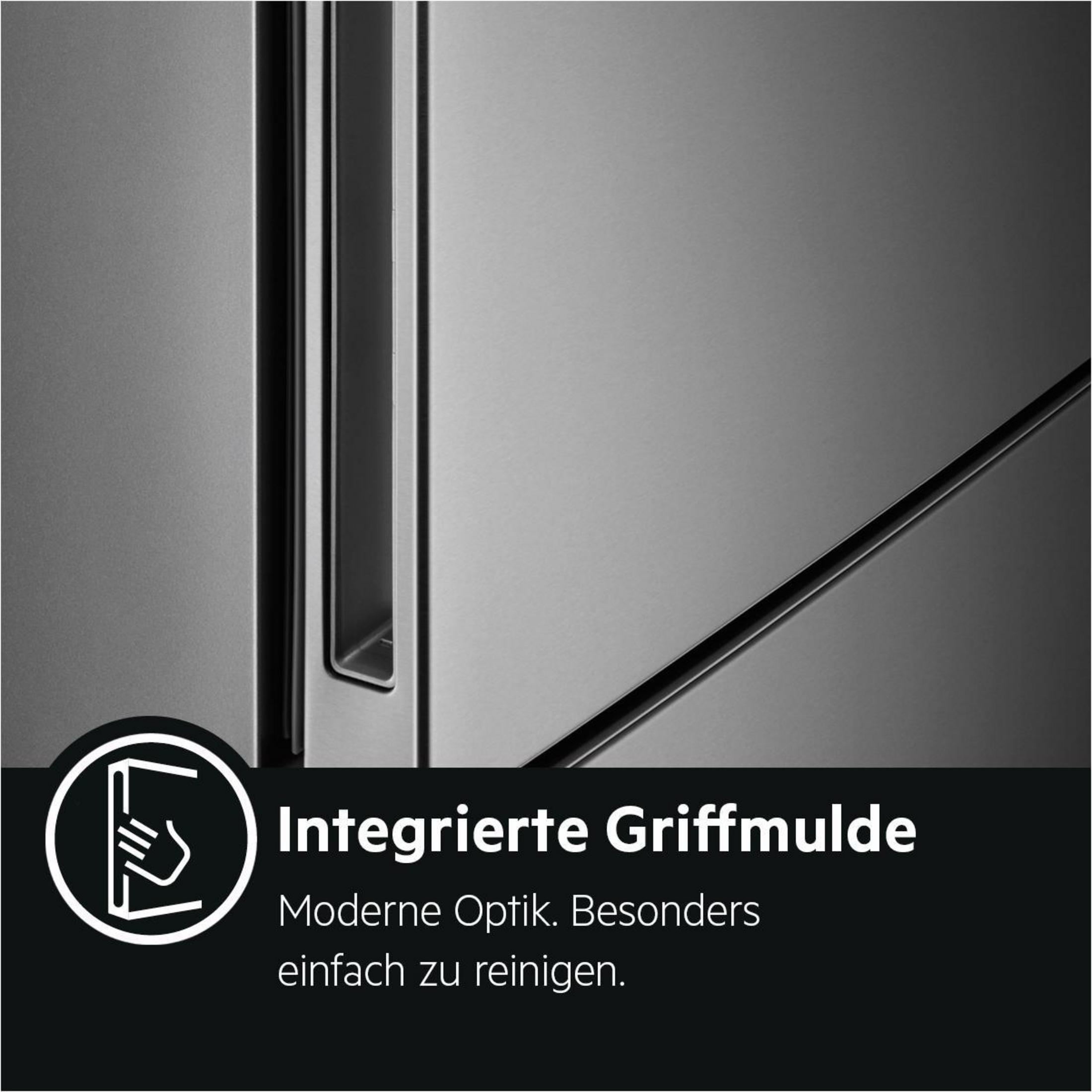 Zbliżenie srebrnych drzwi lodówki z wpuszczonym uchwytem. Tekst w języku niemieckim. Białe tło.