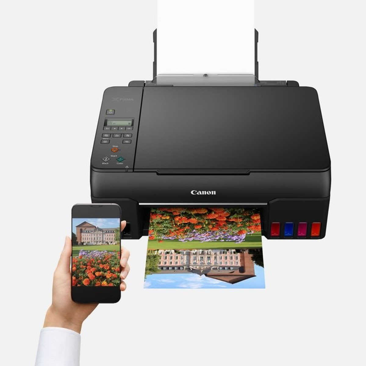 Czarna drukarka Canon drukuje kolorowy obraz, a smartfon wyświetla ten sam obraz.