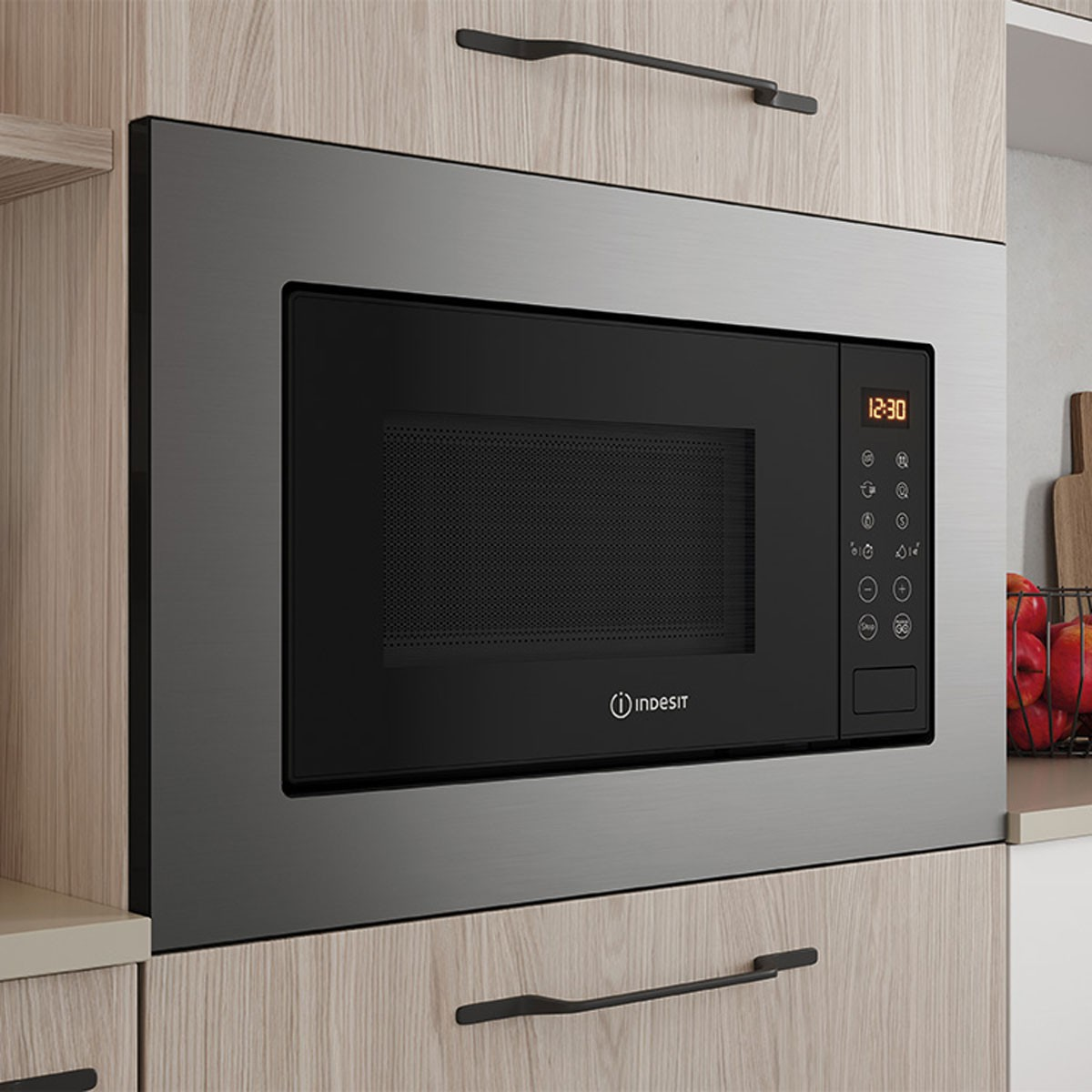 Un horno microondas empotrado con pantalla digital que muestra 12:30 e Indesit.