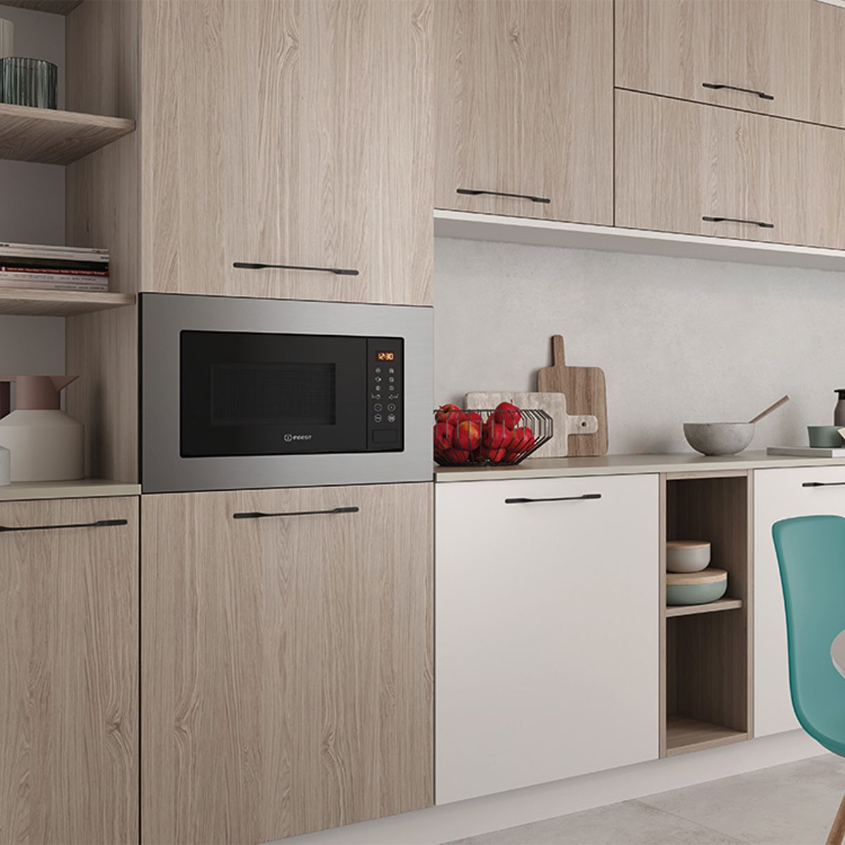 Cocina con gabinetes de madera, microondas y silla verde.