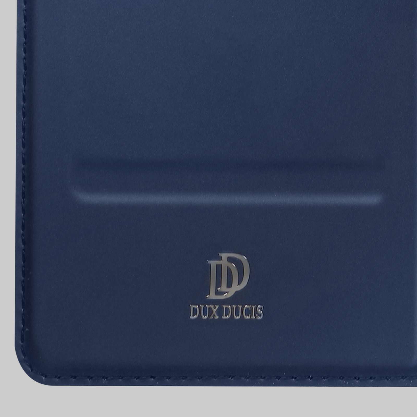 Gros plan sur un étui de téléphone bleu avec le logo argenté DUX DUCIS.