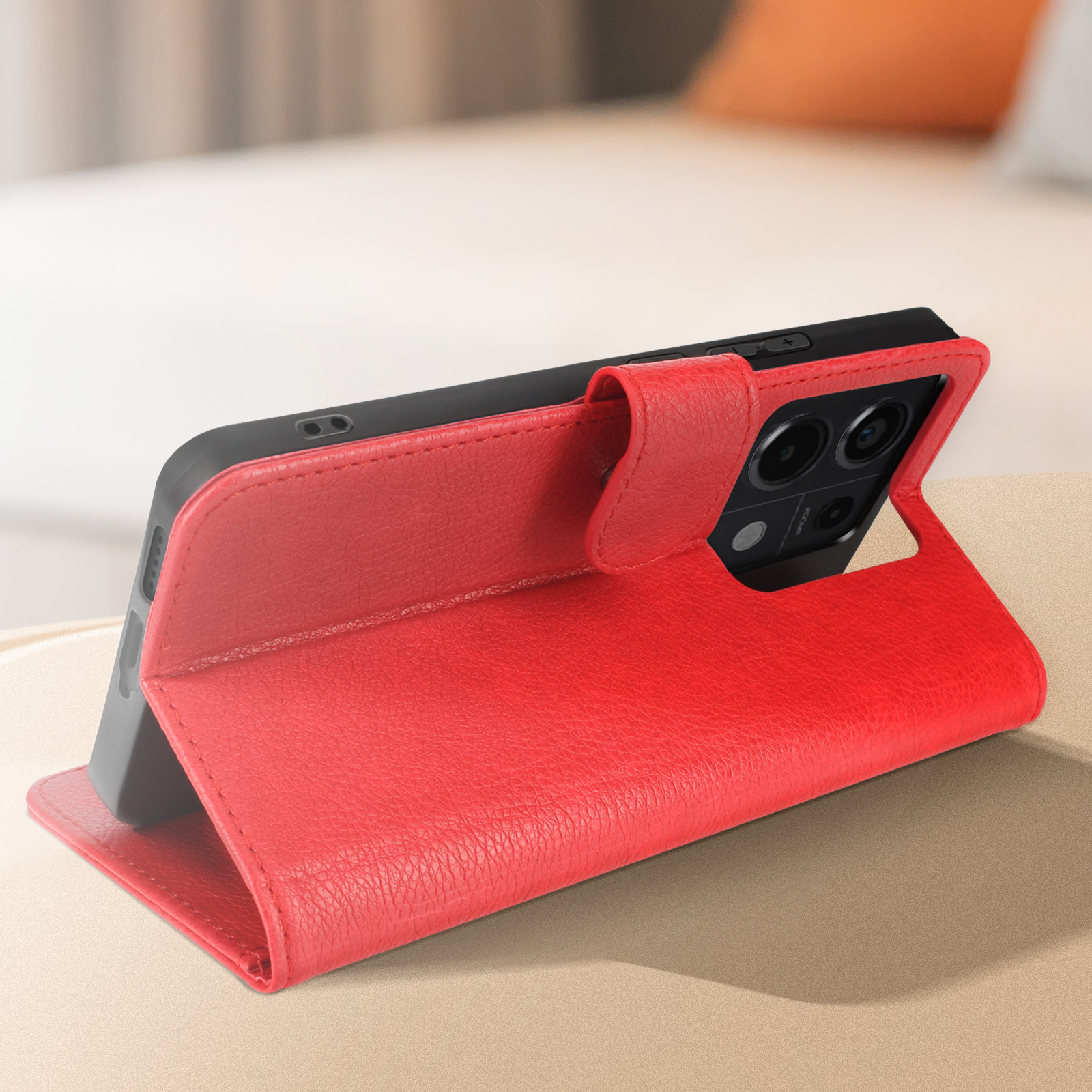 Eine rote Handyhülle offen, ein Handy zeigend. Es liegt auf einem Tisch.