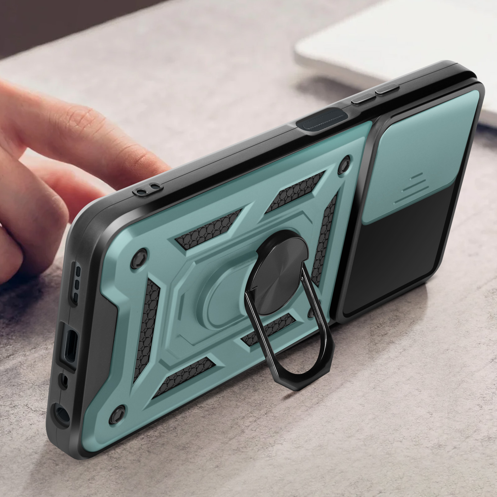 Un telefono con custodia e supporto ad anello. È su una scrivania.