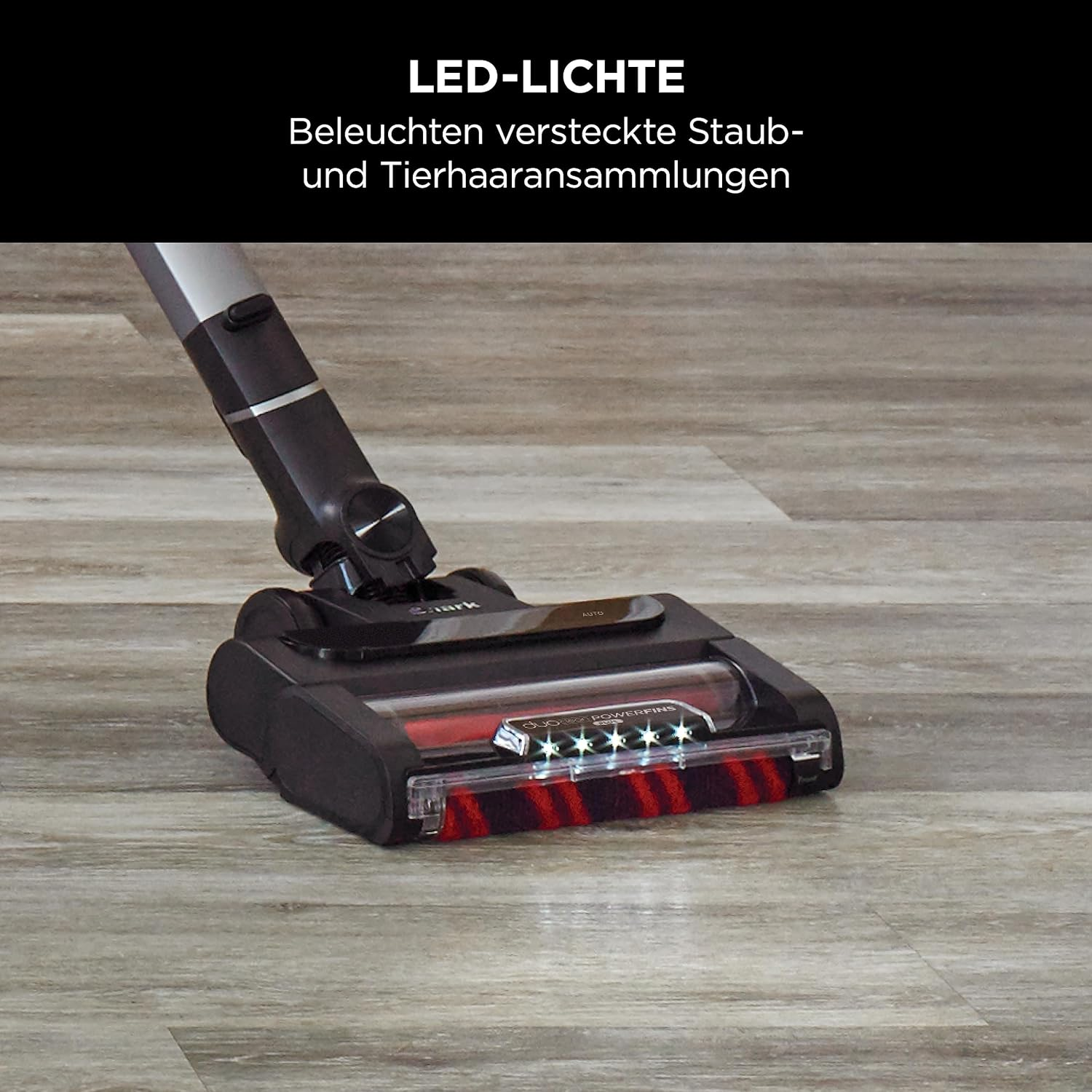 Cabezal de aspiradora con cepillo rojo y luces LED, sobre un suelo de madera.