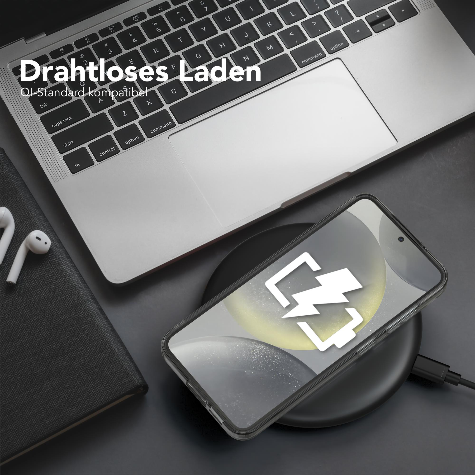 Ein Smartphone auf einem kabellosen Ladegerät, im Hintergrund ein Laptop und Kopfhörer.