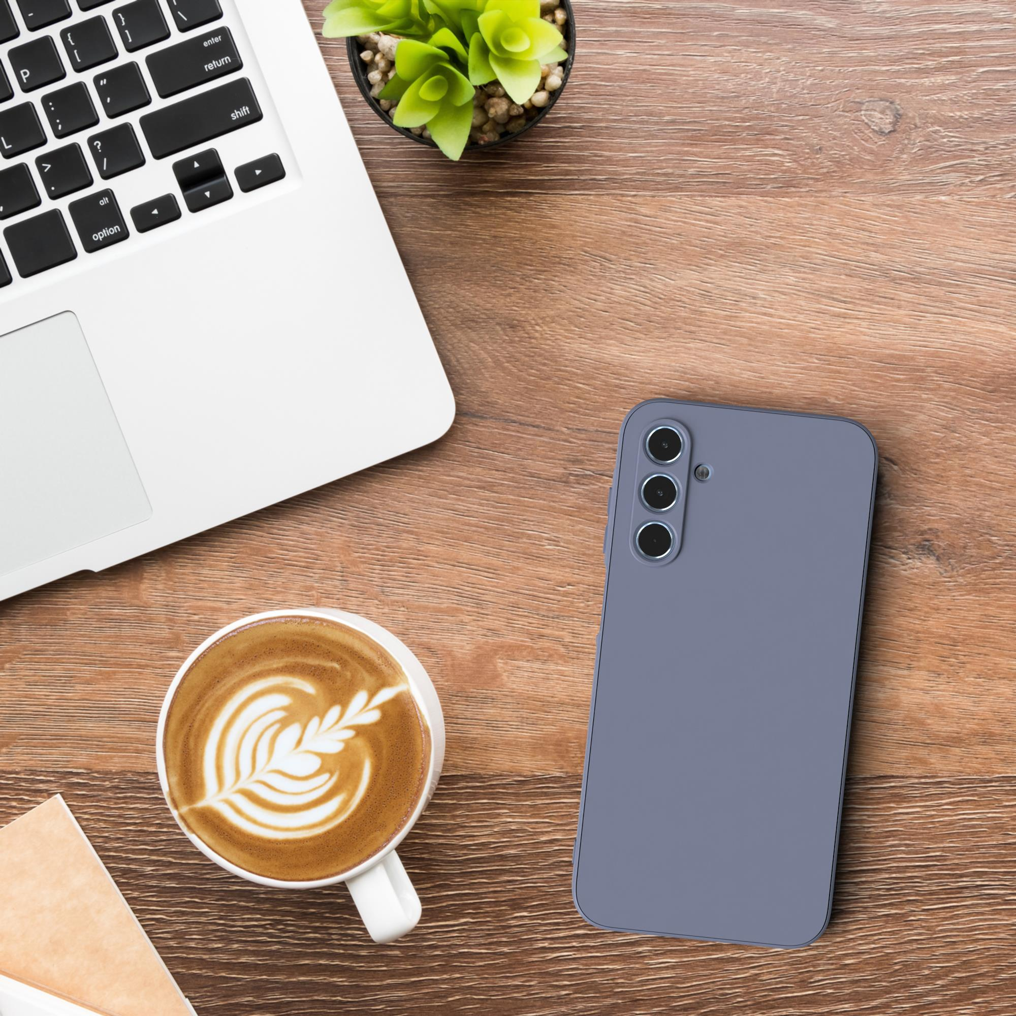 Holzschreibtisch mit Laptop, Kaffeetasse mit Latte Art, Telefon und kleiner Pflanze.