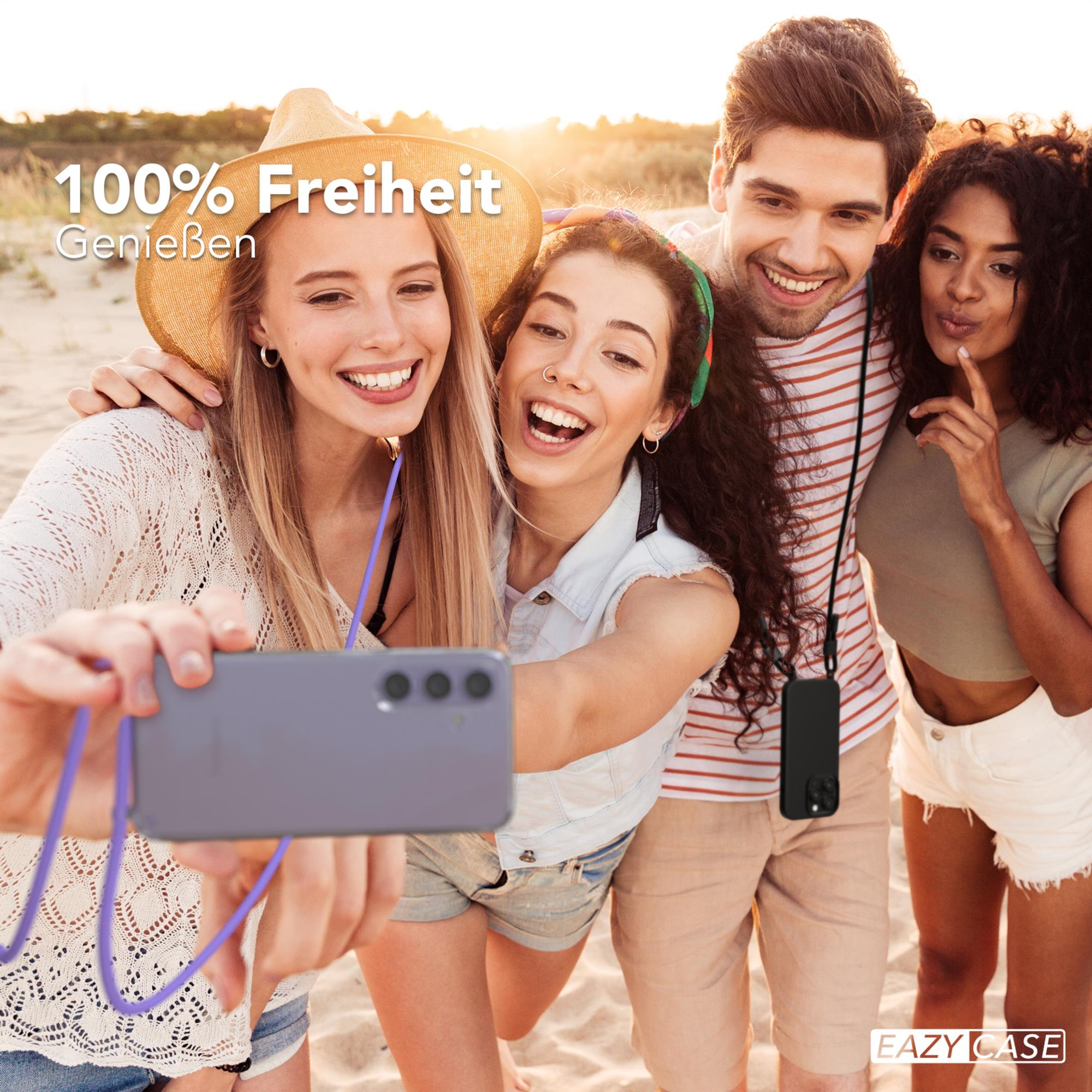 Vier Personen machen ein Selfie am Strand, eine Person hält das Telefon.