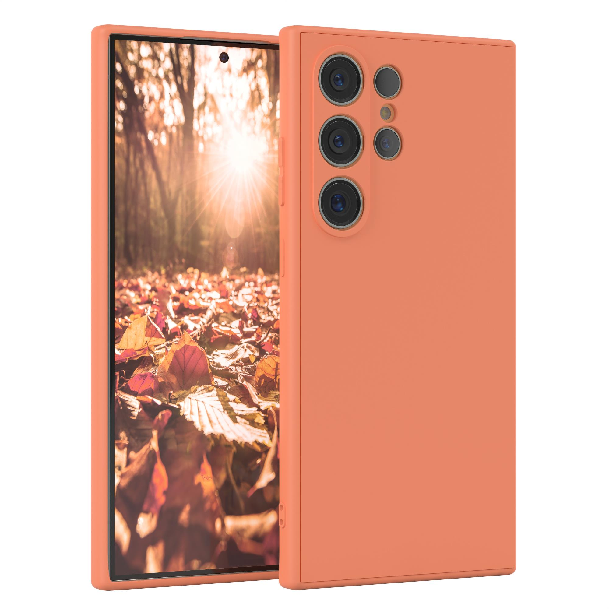 Orangefarbene Handyhülle mit Telefon darin. Das Telefon befindet sich in einem Wald.
