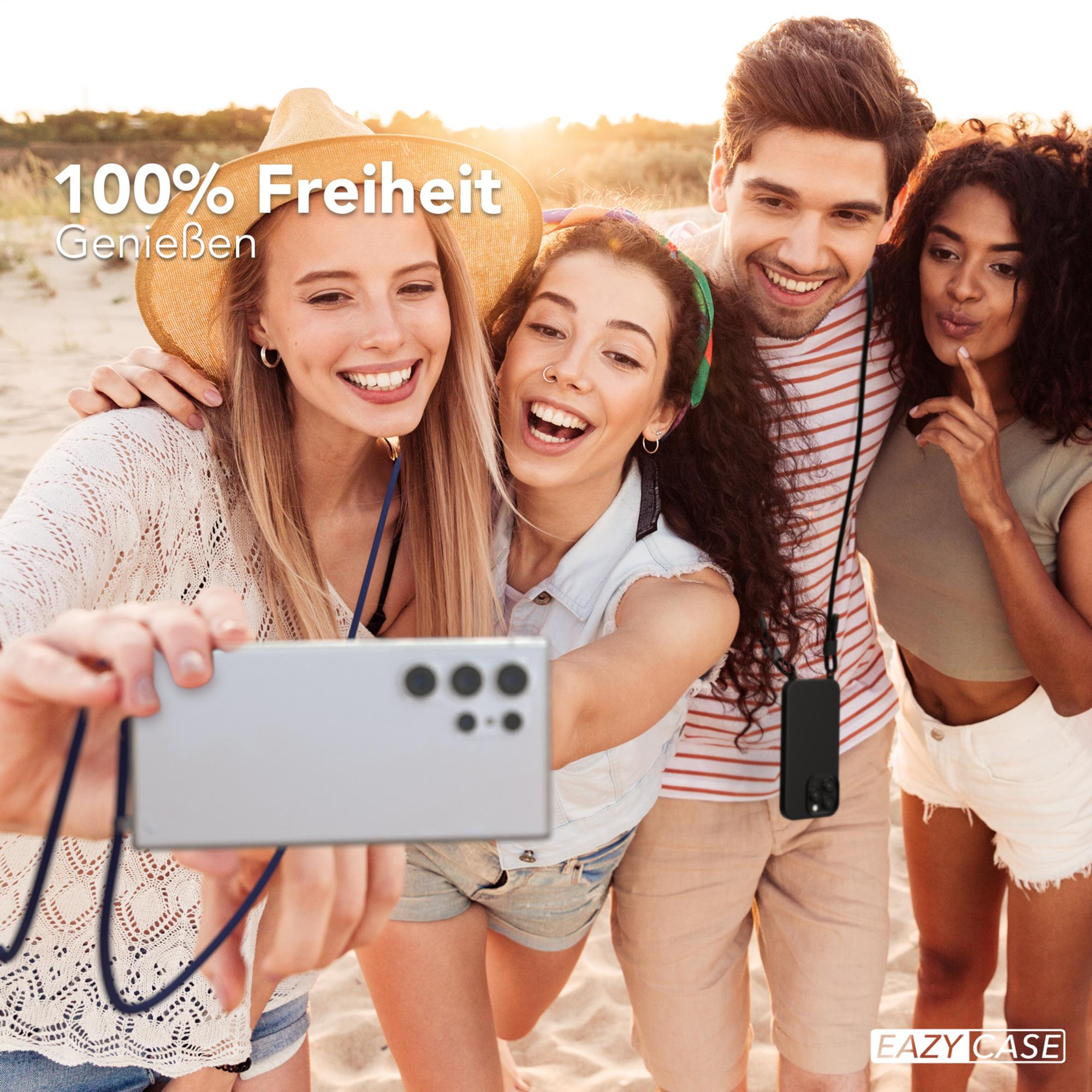 Vier Leute machen Selfie am Strand, nutzen Handy mit Band.