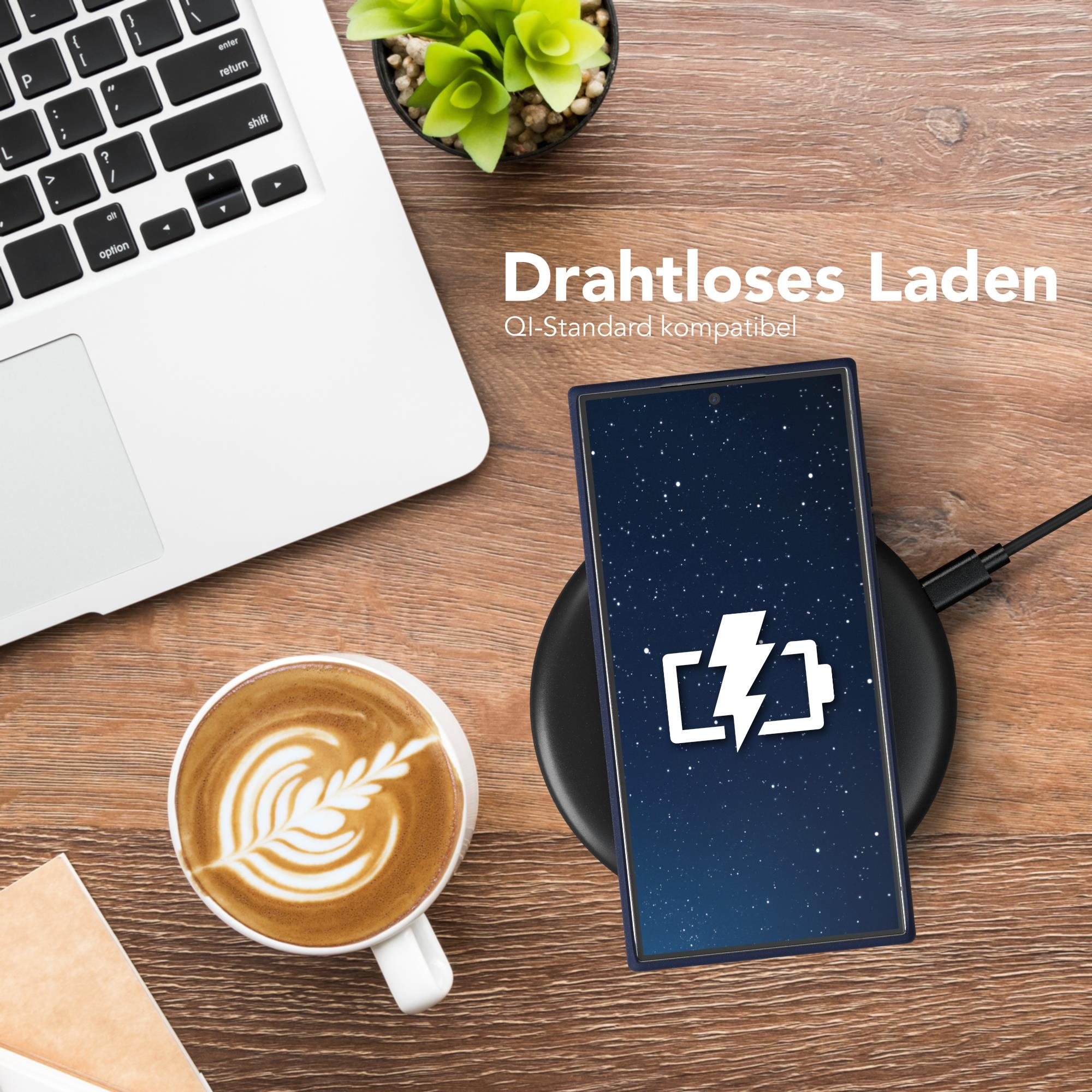 Telefon wird kabellos geladen, neben Laptop und Kaffee.