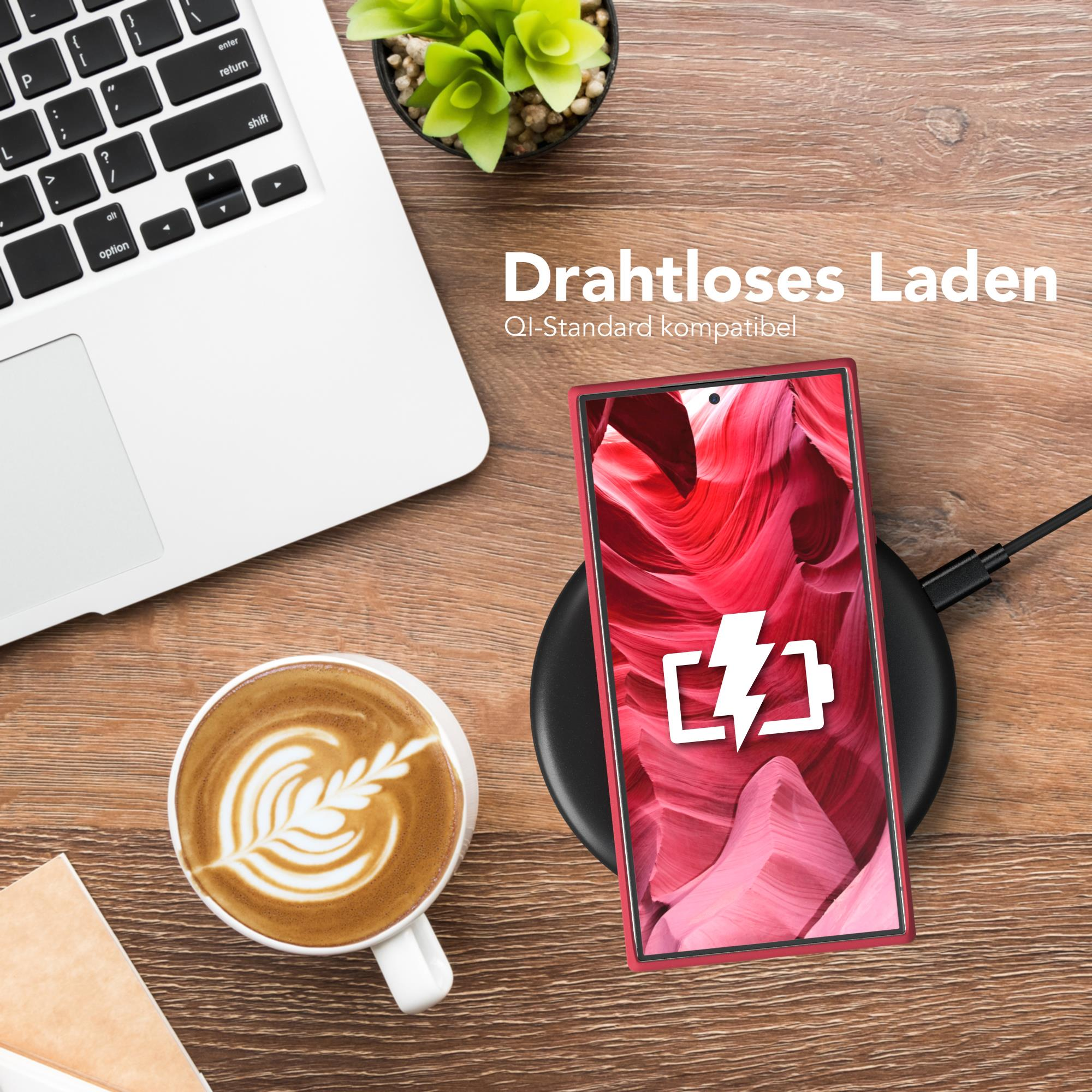 Ein Telefon auf einem kabellosen Ladegerät mit Ladesymbol. Ein Laptop und eine Kaffeetasse sind auch da.