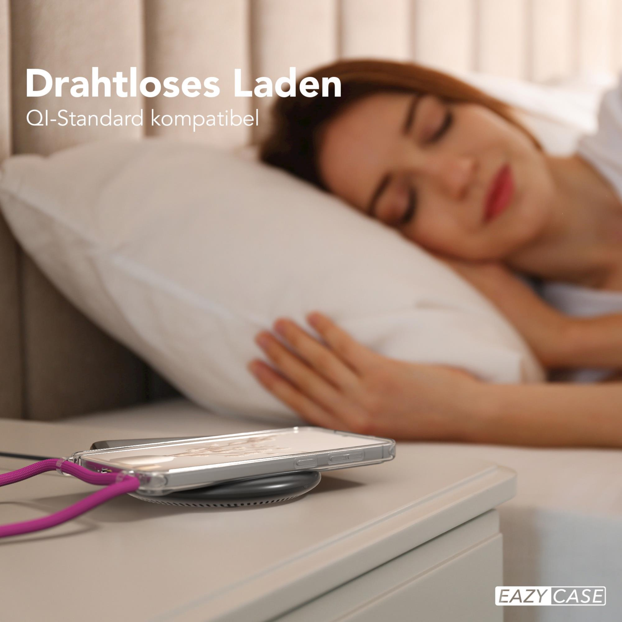 Schlafende Frau mit kabellos ladendem Telefon. Ein weißer Nachttisch im Vordergrund.