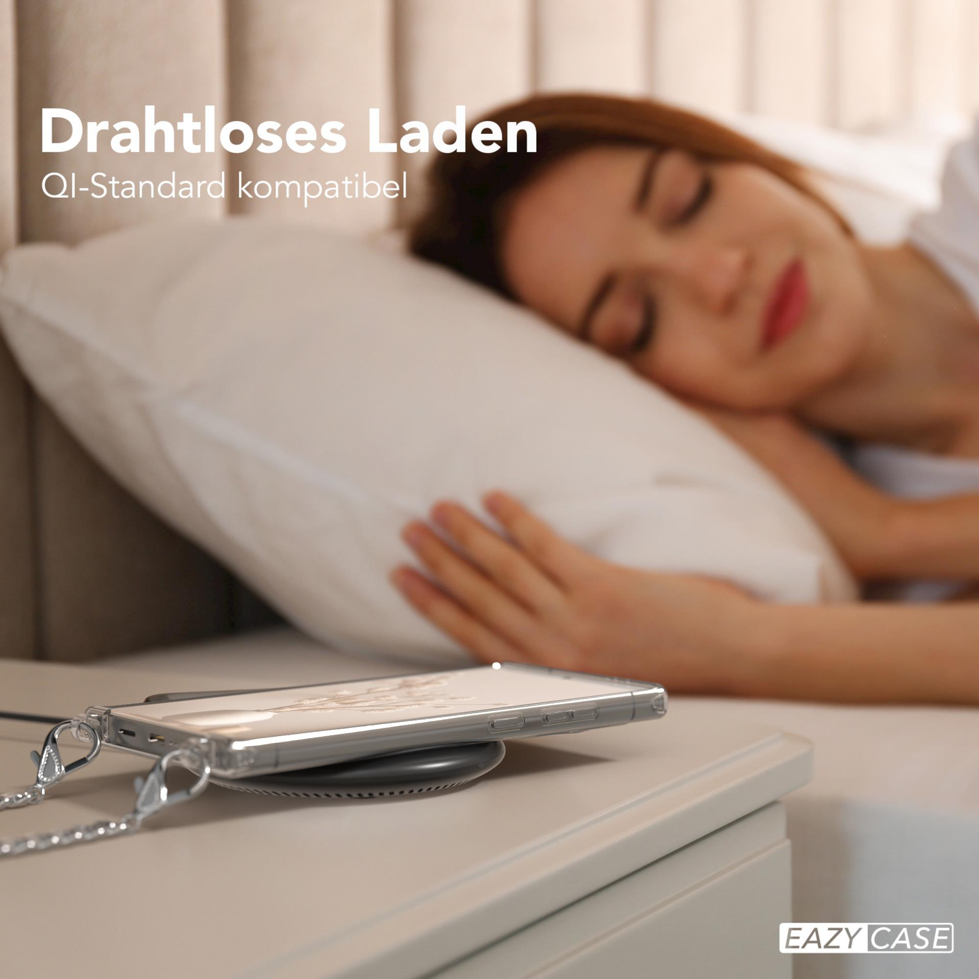 Eine Frau schläft auf einem Bett. Ein Telefon liegt auf einem kabellosen Ladegerät auf einem Nachttisch.