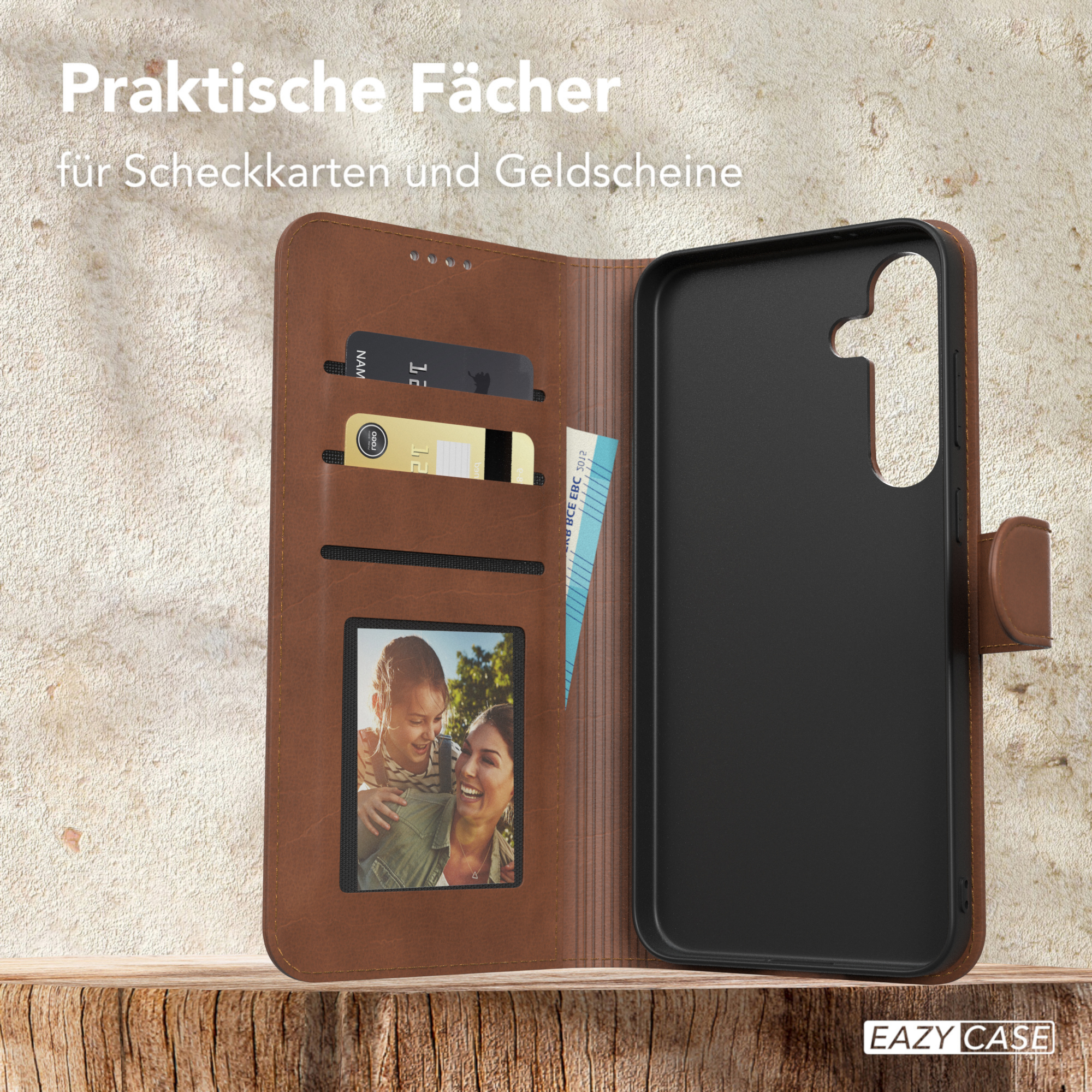 Geöffnete braune Handyhülle mit Karten, Foto und Telefon auf Holzoberfläche.