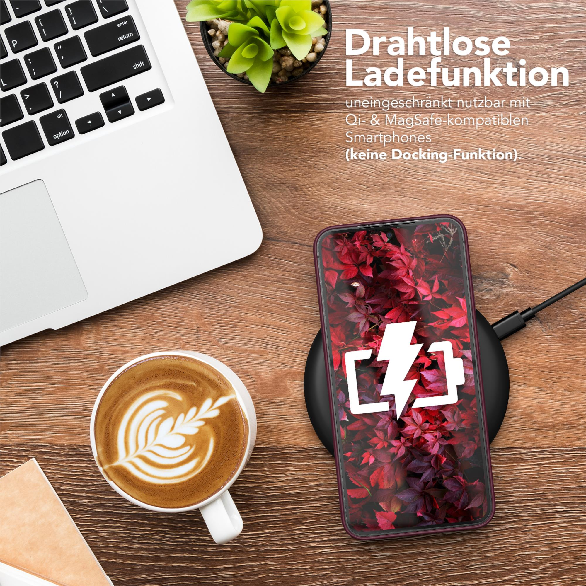 Laptop, Kaffee und Telefon, das kabellos auf einer Holzoberfläche geladen wird.