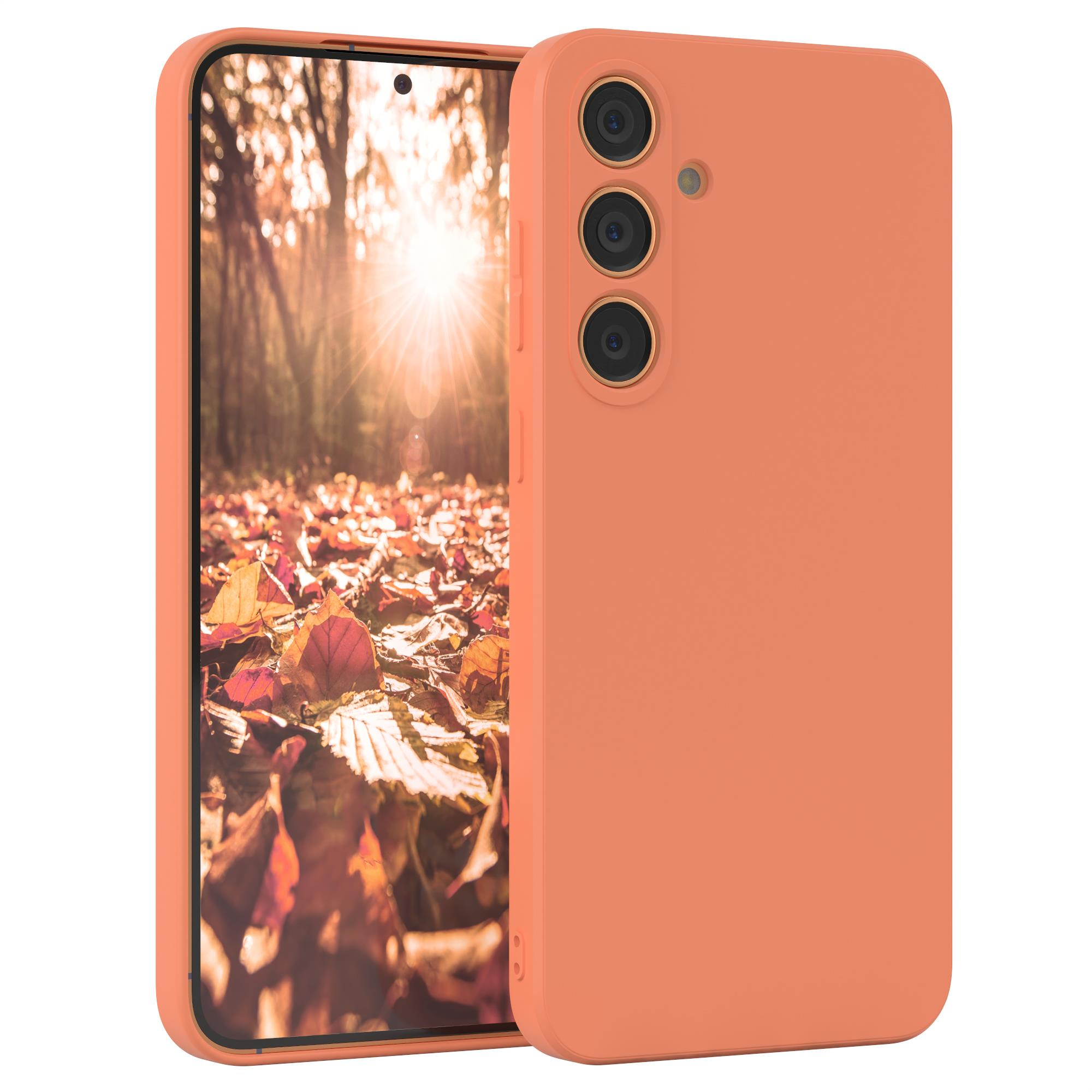 Orangefarbene Handyhülle. Verschwommener Hintergrund mit Herbstlaub und Sonnenlicht.