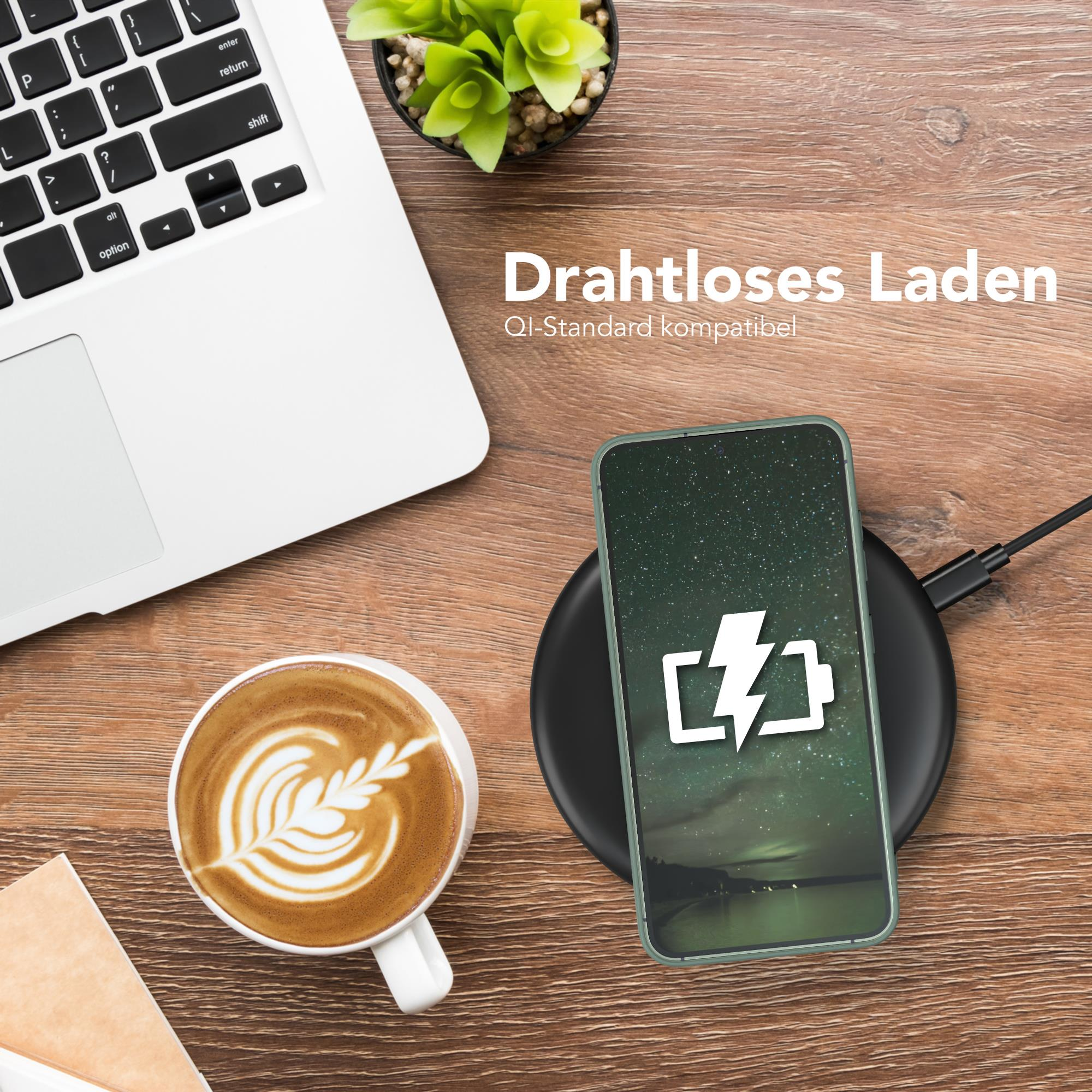 Ein Telefon auf einem Ladegerät mit einer Kaffeetasse und einem Laptop.