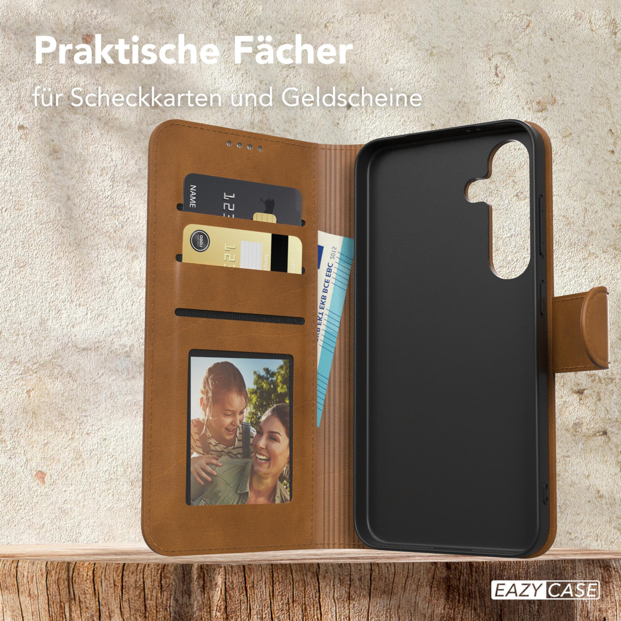 Braune Handyhülle offen, zeigt Karten, ein Foto und das Telefon. Holztisch.