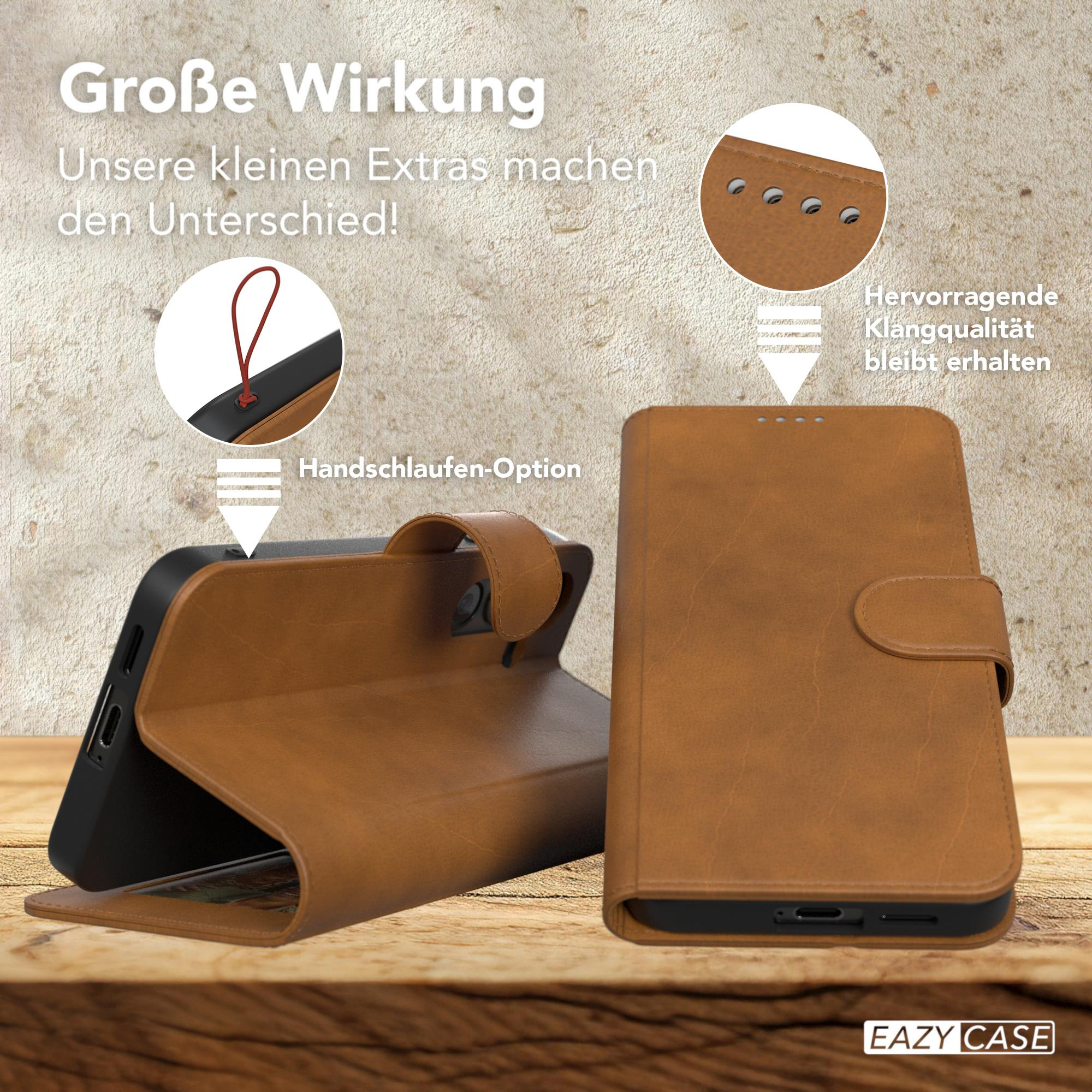 Braune Leder-Handyhülle. Text: Handschlaufen-Option, tolle Qualität. Holztisch. Telefon teilweise drin.
