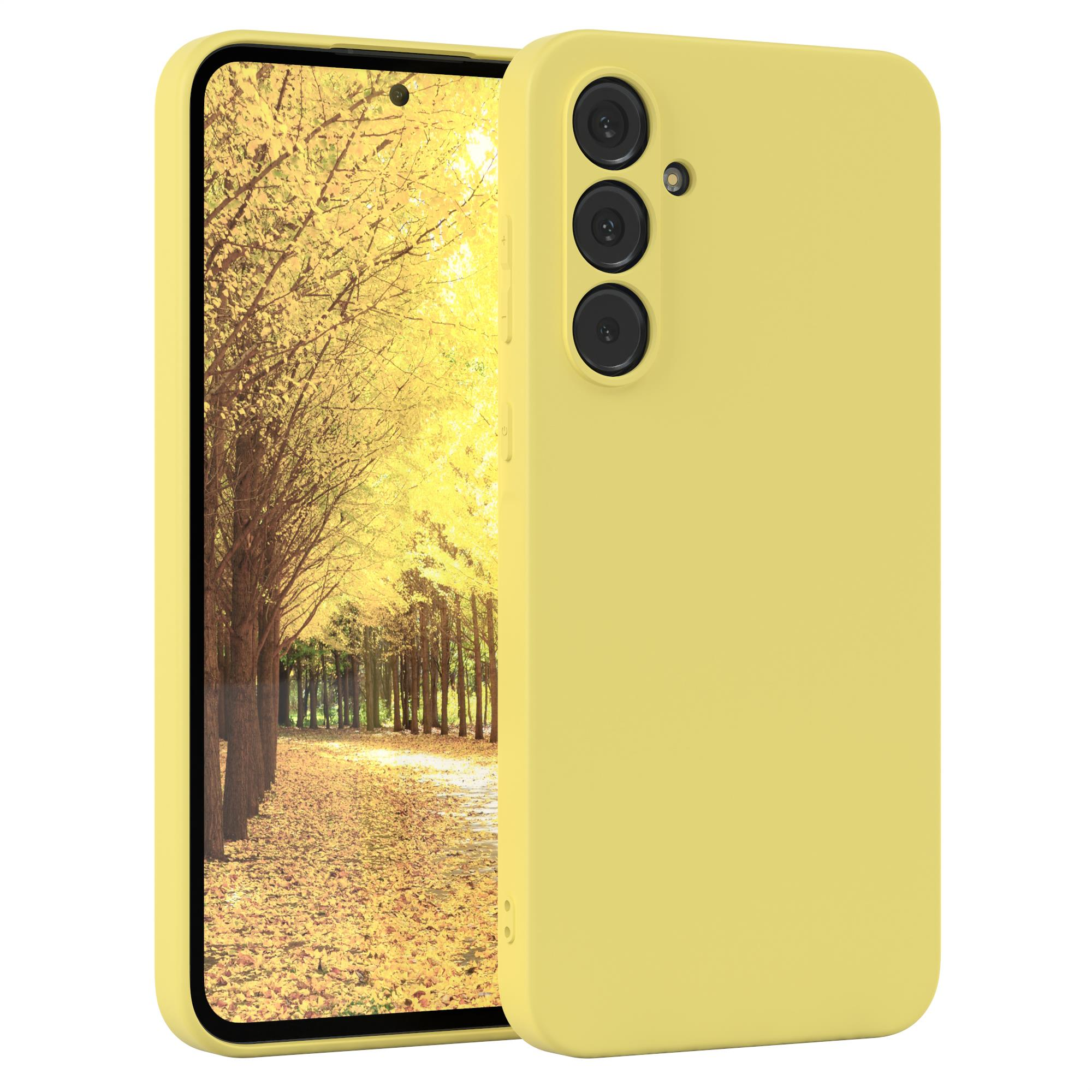 Eine gelbe Handyhülle auf einem Telefon. Das Telefon befindet sich vor einem Herbstwald.