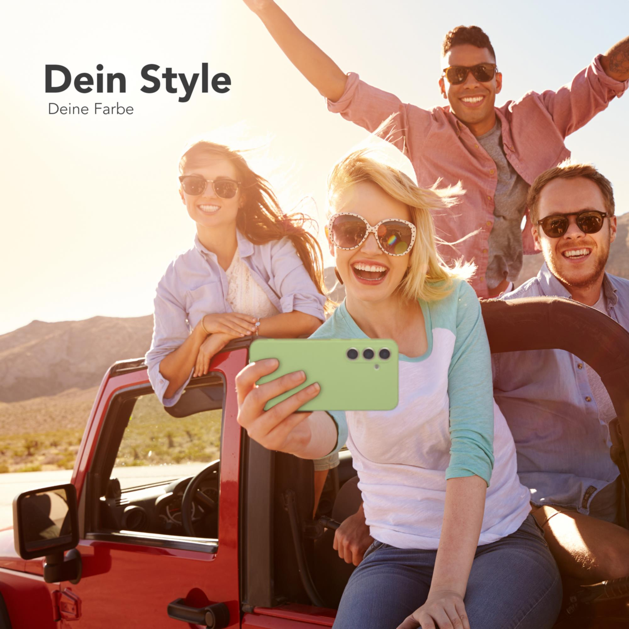 Vier Personen in einem Auto machen ein Selfie mit einem grünen Telefon. Sie lächeln.