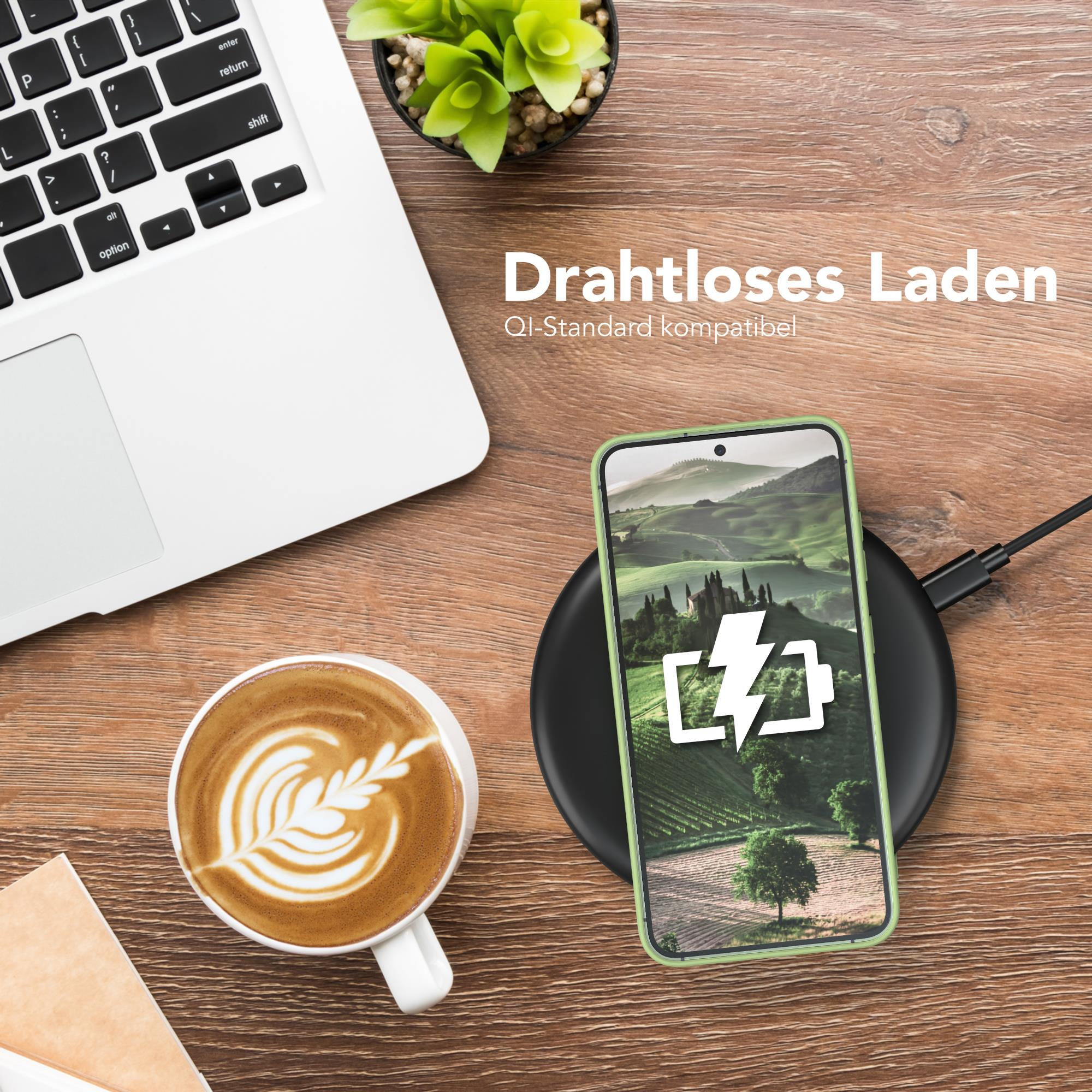 Telefon auf Ladegerät. Laptop und Kaffee auf dem Schreibtisch.