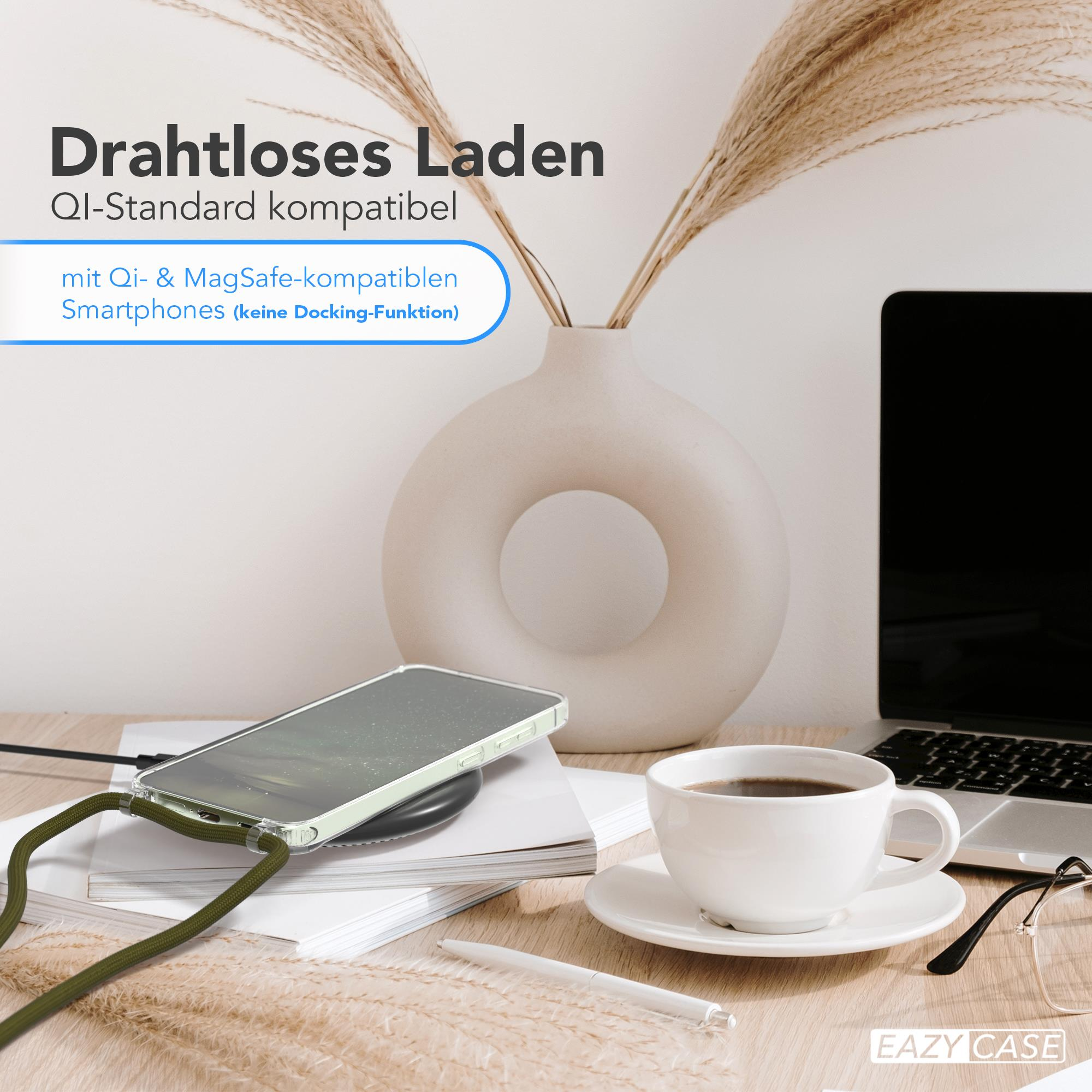 Telefon auf kabellosem Ladegerät mit grünem Kabel. Neben Kaffeetasse, Laptop und Vase.