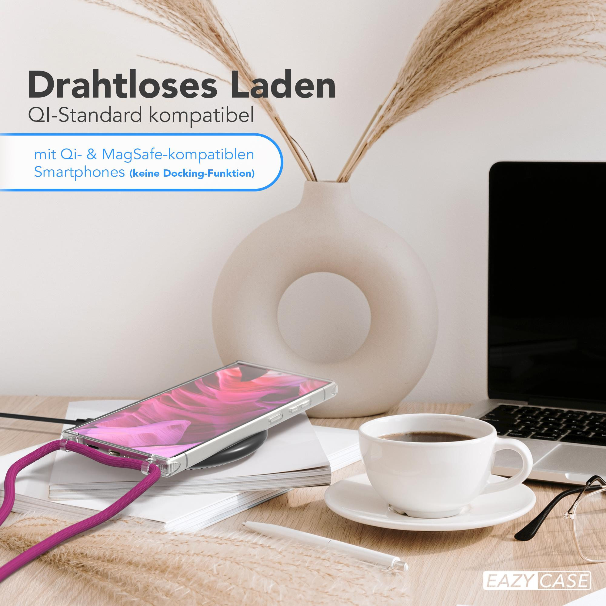 Ein Telefon auf einem kabellosen Ladegerät, eine Kaffeetasse und ein Laptop.