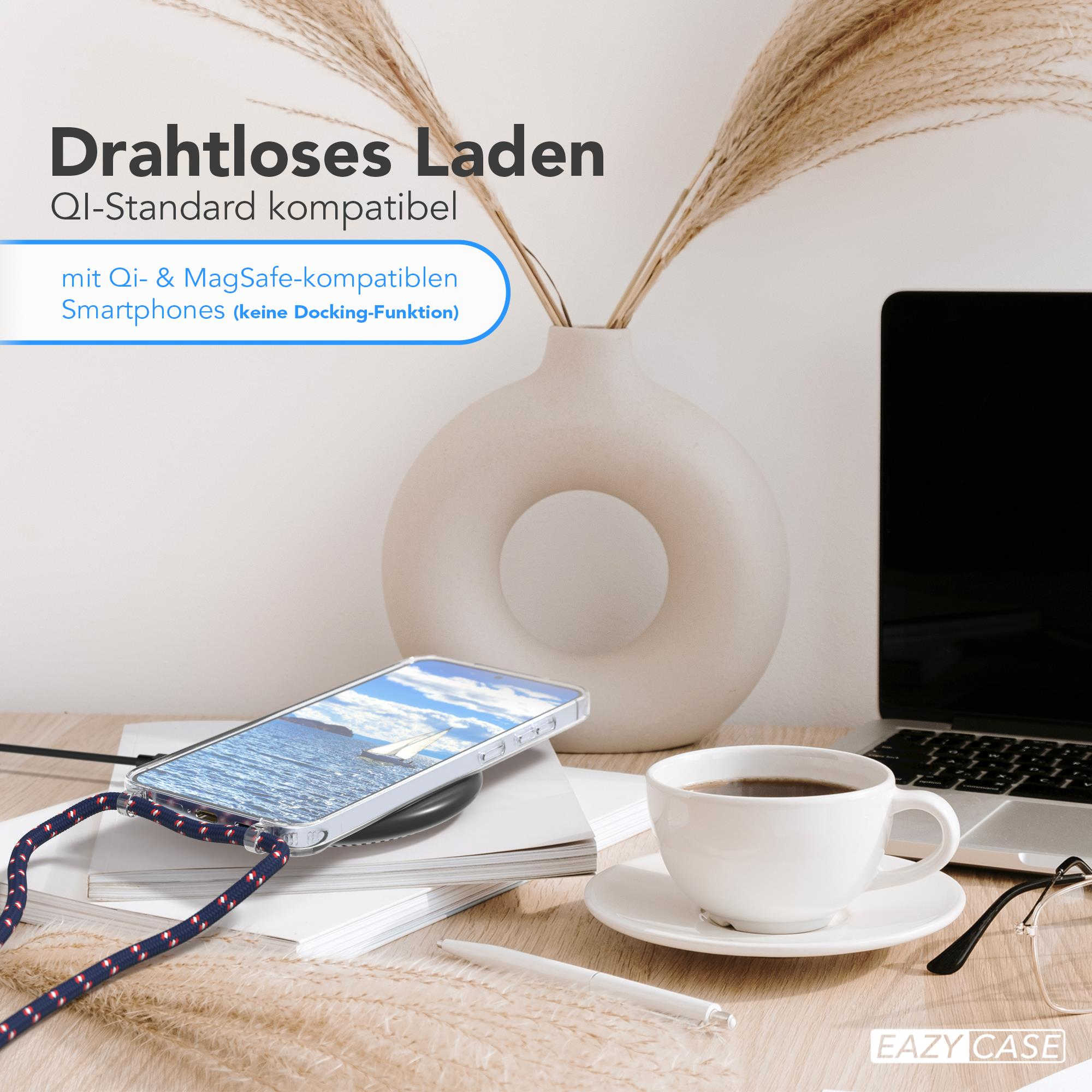 Smartphone auf kabellosem Ladegerät, Kaffee, Laptop und Dekorationen auf Holztisch.