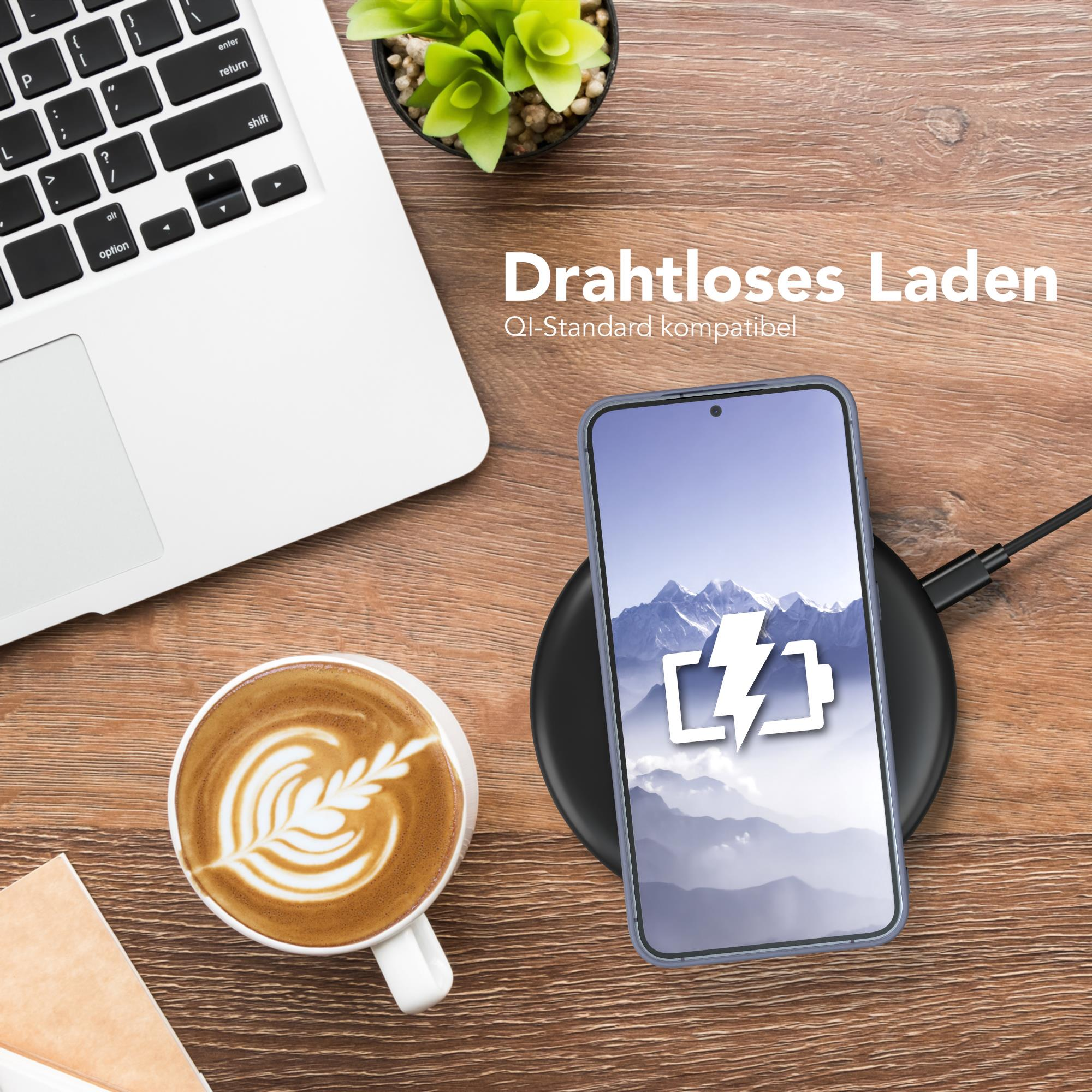 Telefon lädt auf dem Schreibtisch, neben Laptop und Kaffeetasse.
