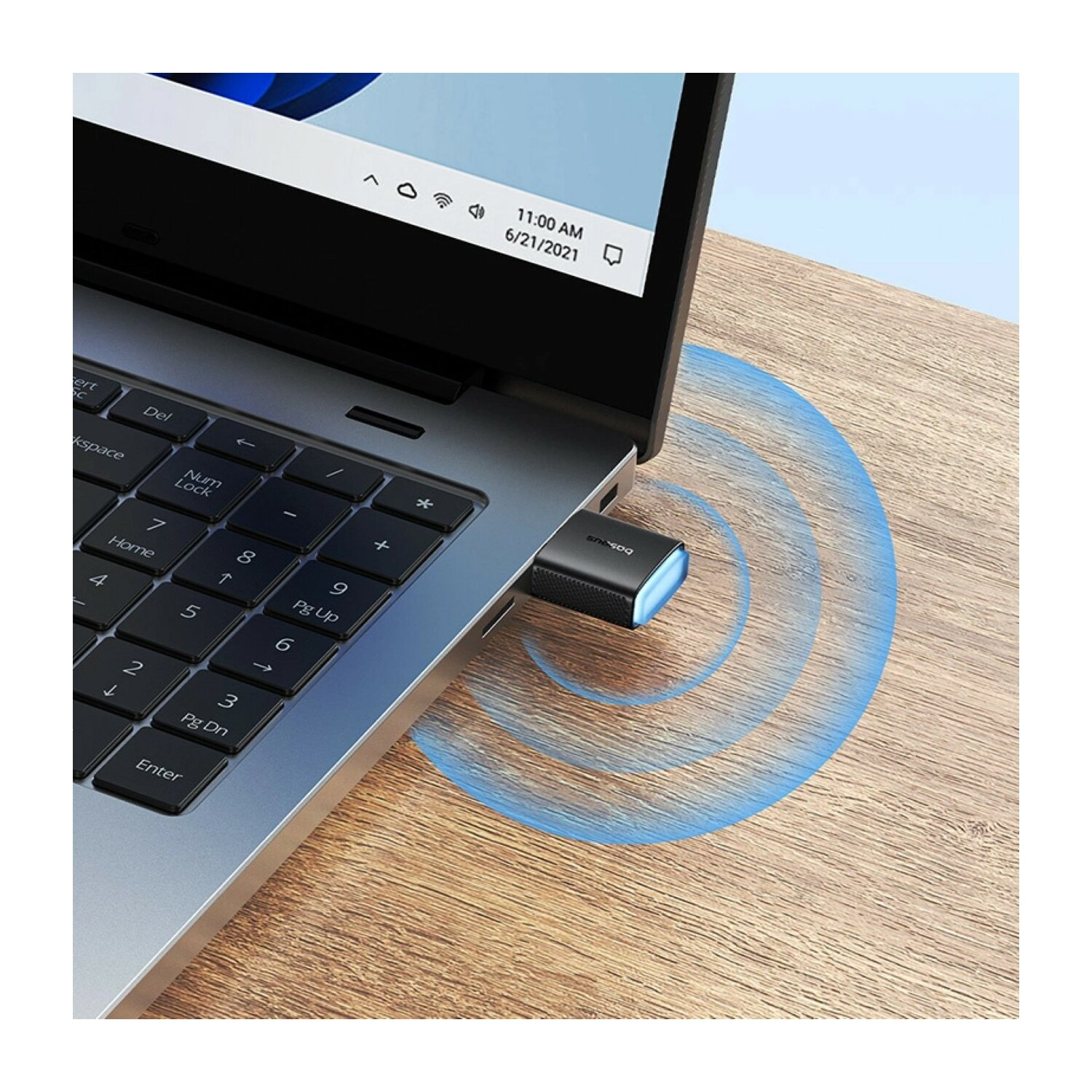 Laptop z podłączonym kluczem USB. Pokazano niebieskie linie sygnału.