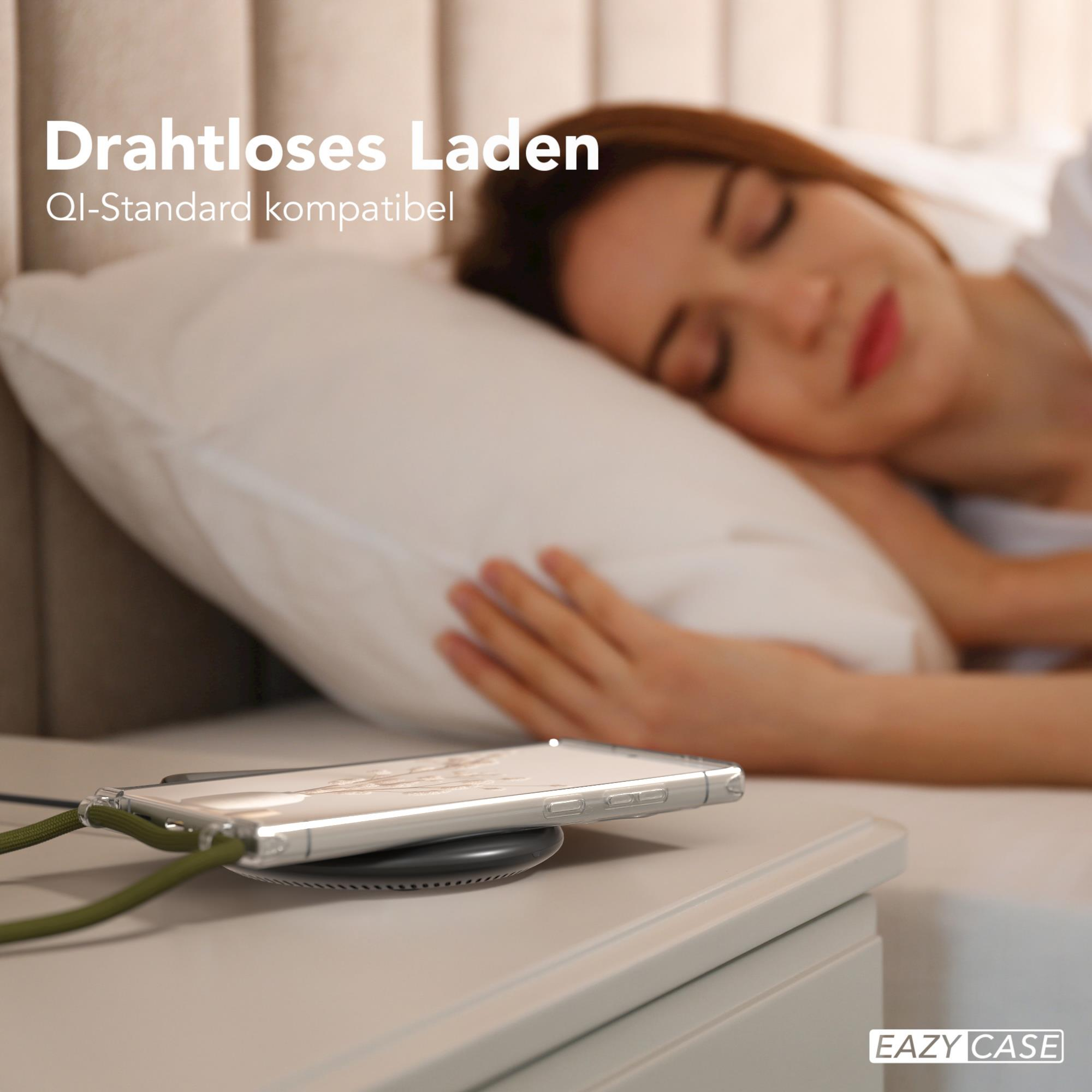 Telefon lädt kabellos auf Nachttisch. Frau schläft im Hintergrund.