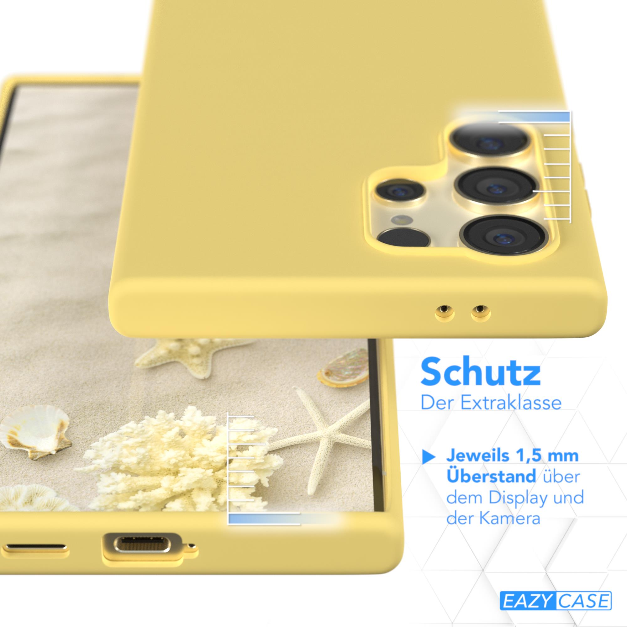 Gelbe Handyhülle auf Sand mit Muscheln, Text unten. Schutzdetails.