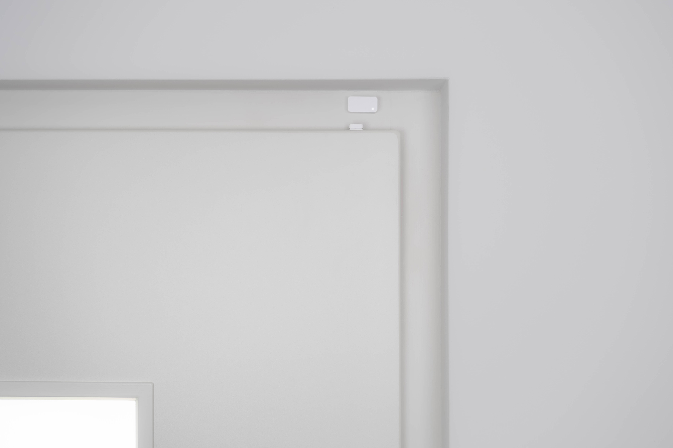 An interior corner with a white recessed area and a small square object.
