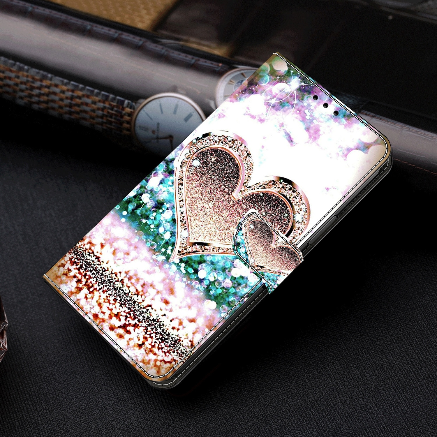 Handyhülle mit Glitzerherzen, Glitzerhintergrund und goldfarbenem Verschluss.