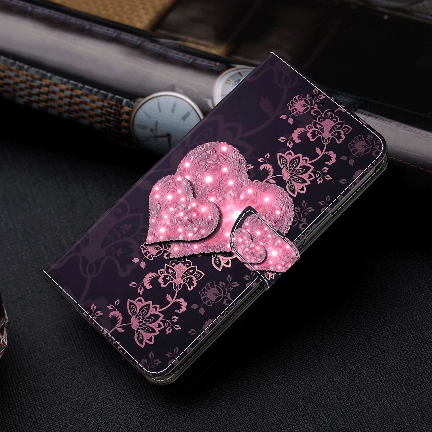 Una funda de teléfono con corazones y un estampado floral. La funda está abierta con un teléfono dentro.