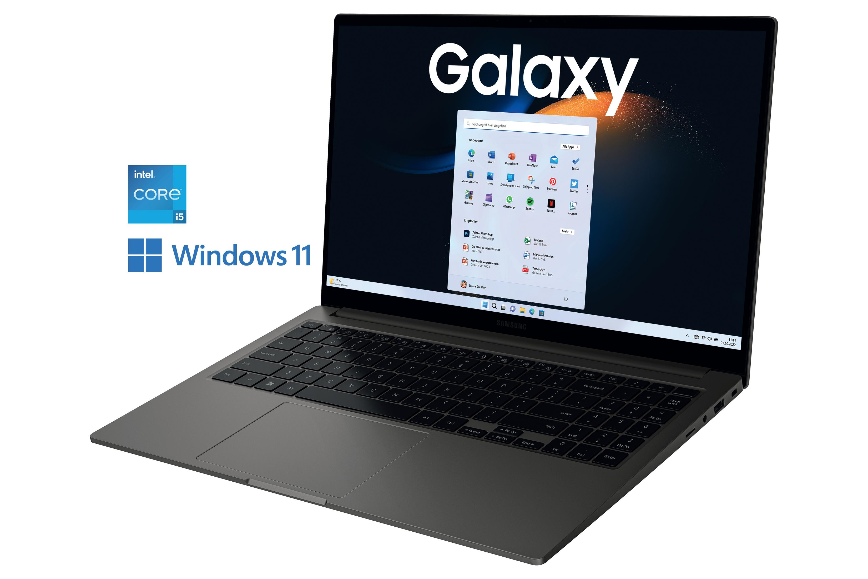 Ein Laptop mit Galaxy-Logo, geöffnet auf einem Schreibtisch mit Windows 11.
