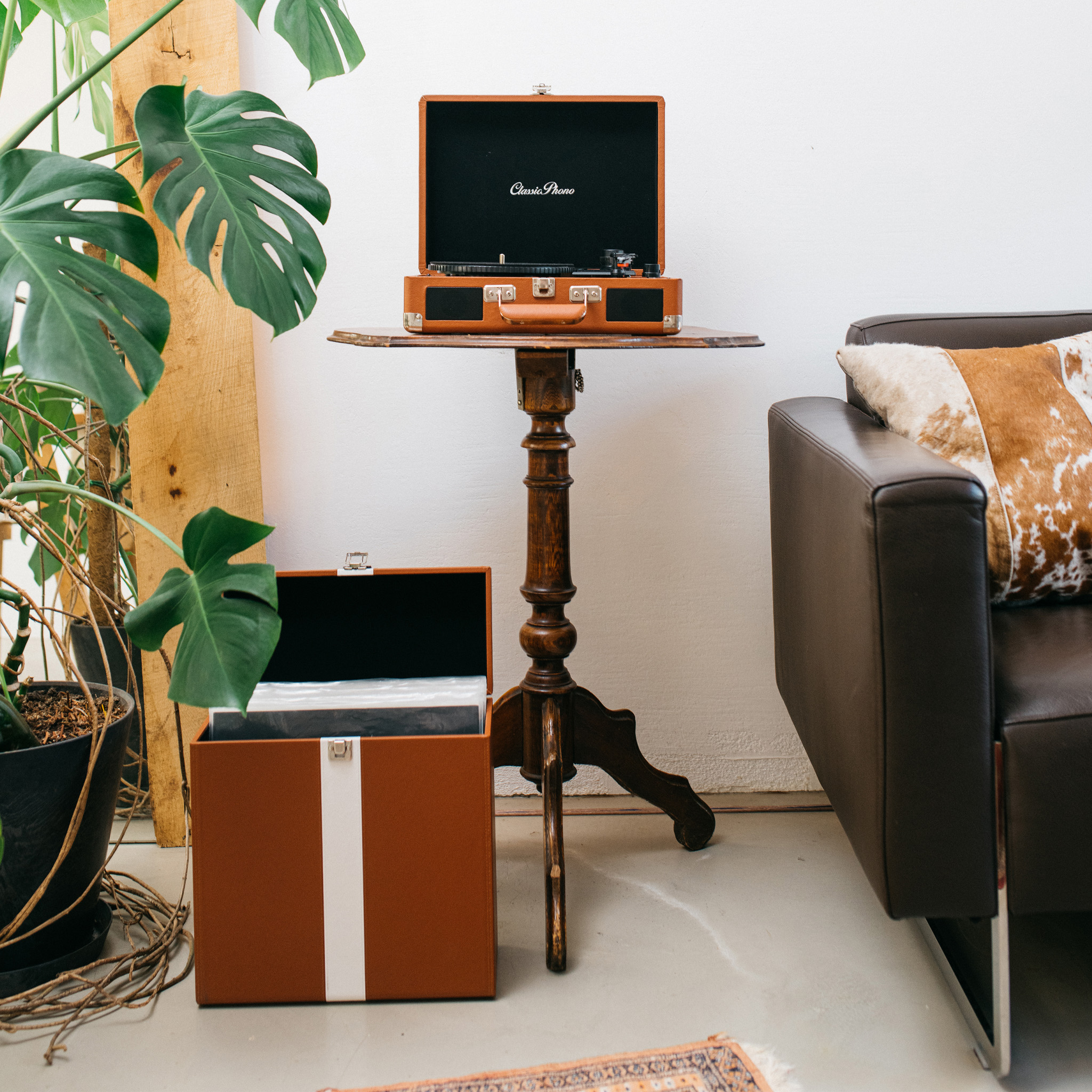 Gramofon, płyty i pudełko do przechowywania płyt winylowych na stole i podłodze.